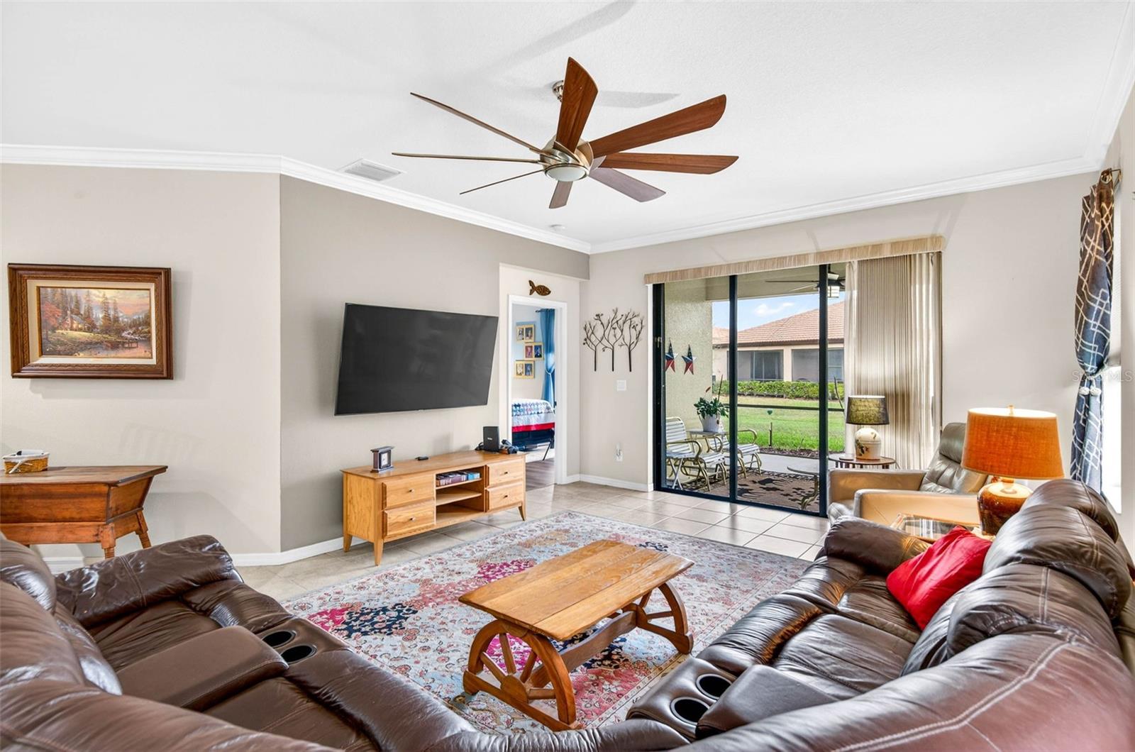Family room complete with ceiling fan, sliding glass doors to screened/covered lanai.
