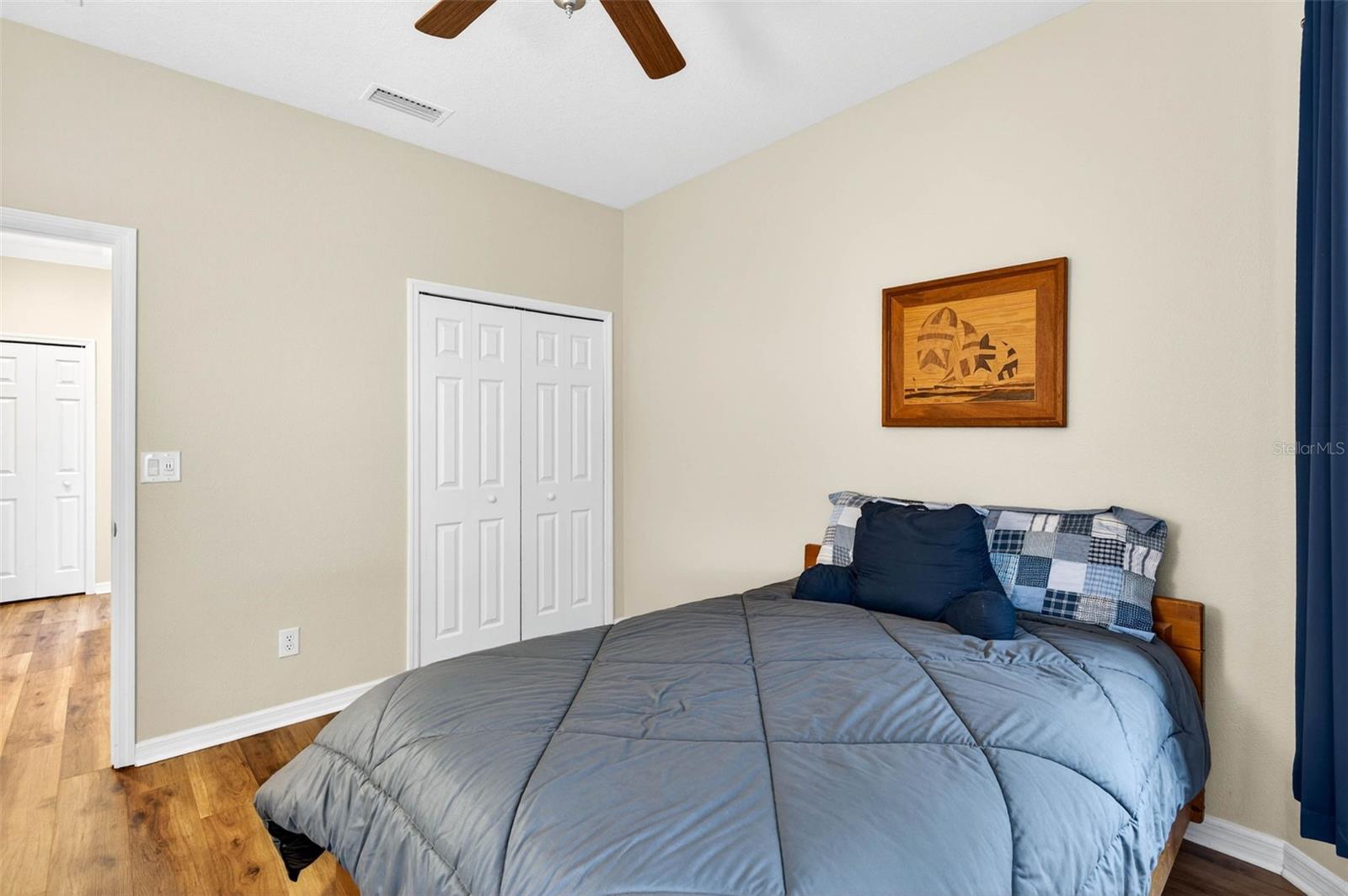 Secondary bedroom with built in closet and ceiling fan. Luxury vinyl plank flooring.