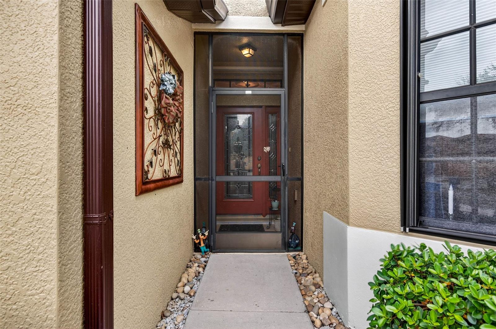 Screened and covered front entry with screen door.