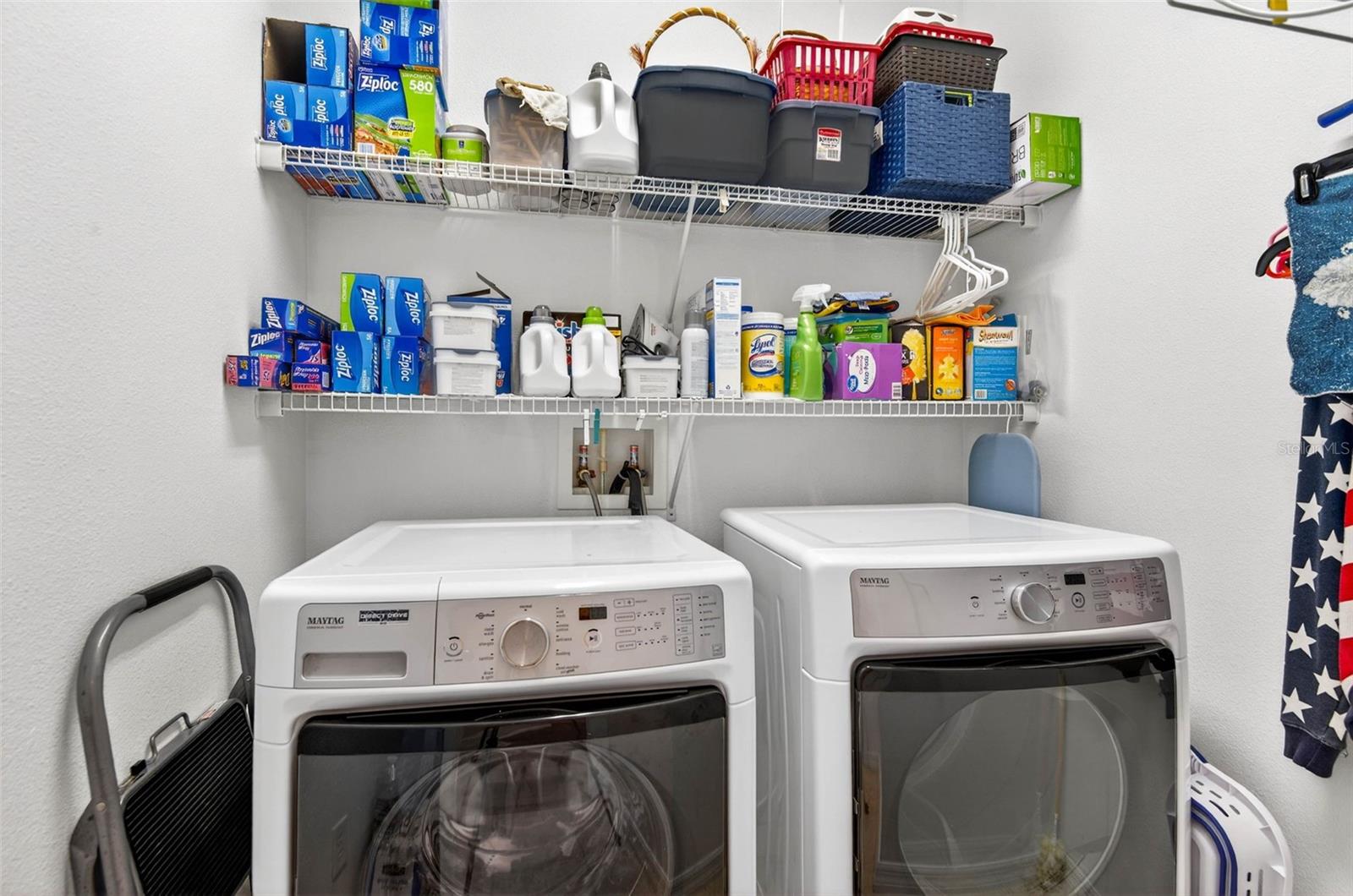 Laundry room with shelving and hanging space. Washer and dryer do convey with home.