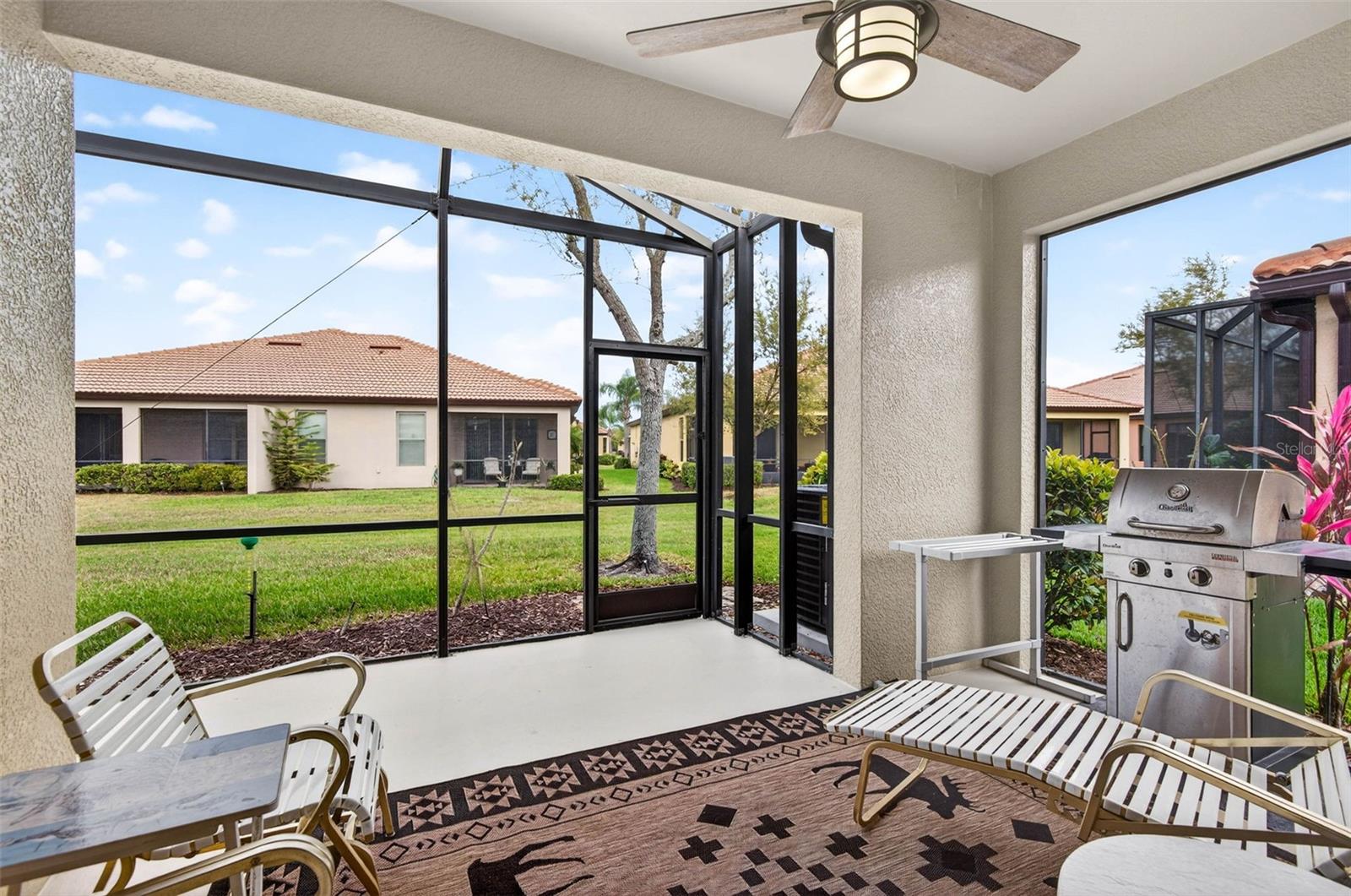 Screened and covered lanai with ceiling fan.