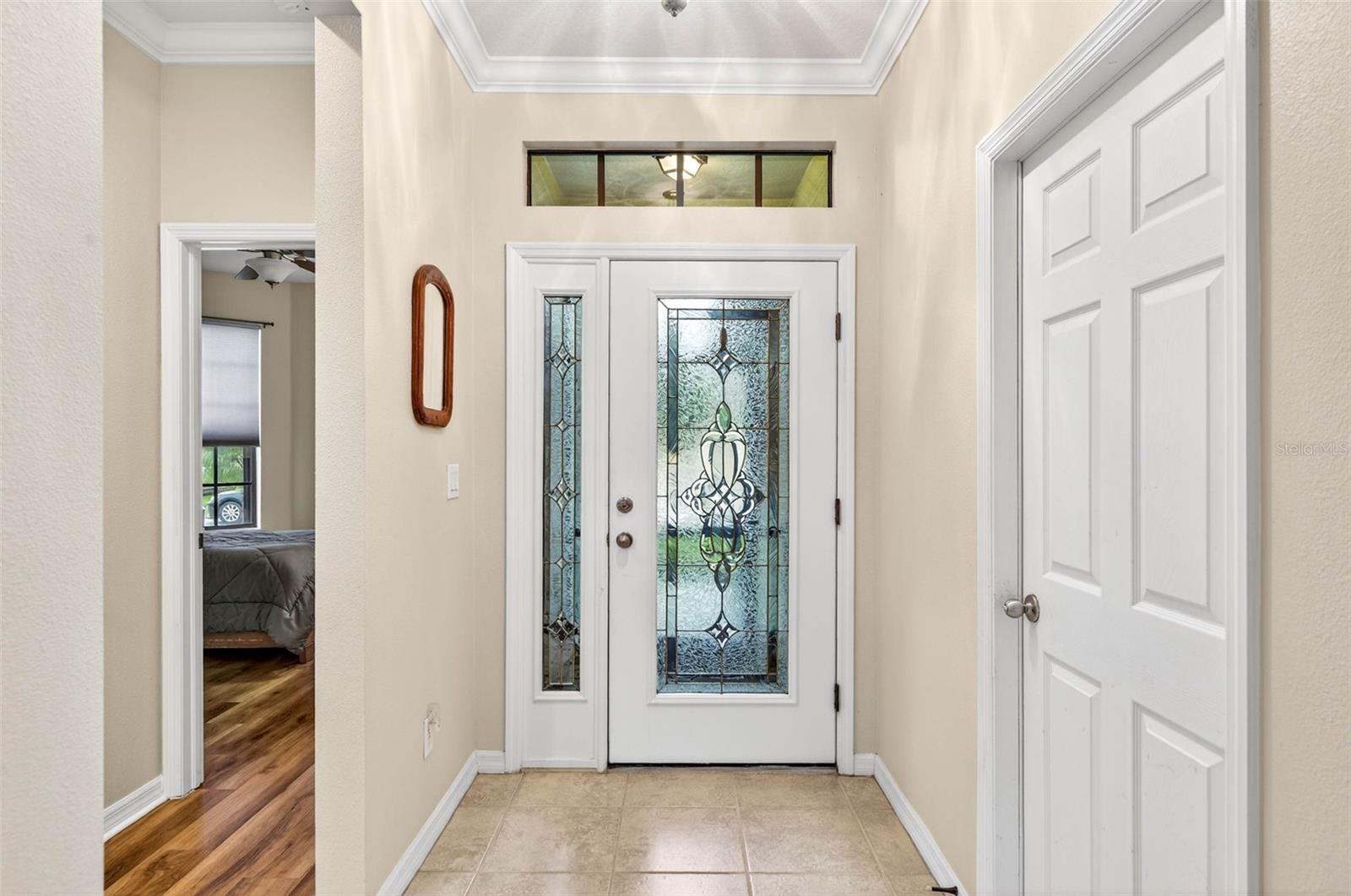 Foyer facing entry. Secondary bedroom to the left. Garage entry to the right.