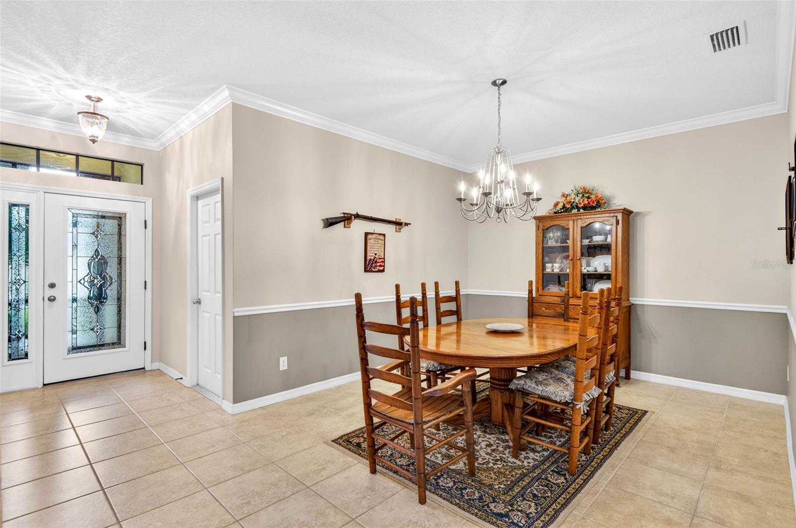 Generously sized dining room with chair rail and crown molding