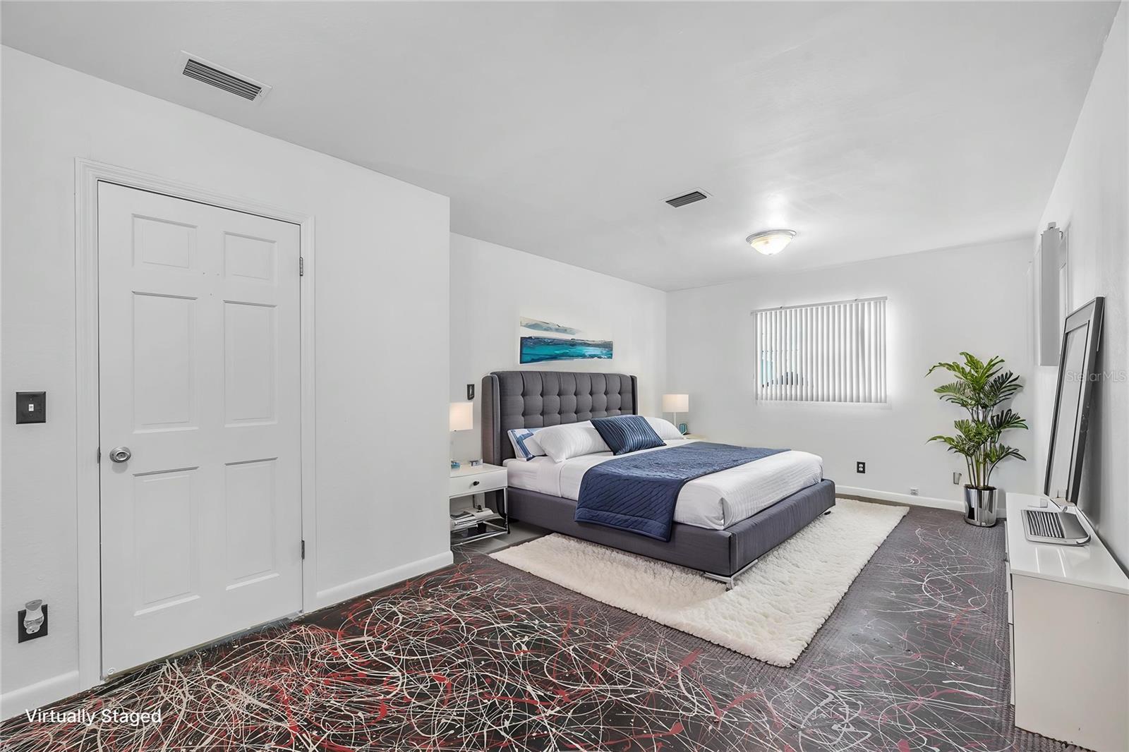 Secondary bedroom with build-in closet has a unique painted cement floor treatment.