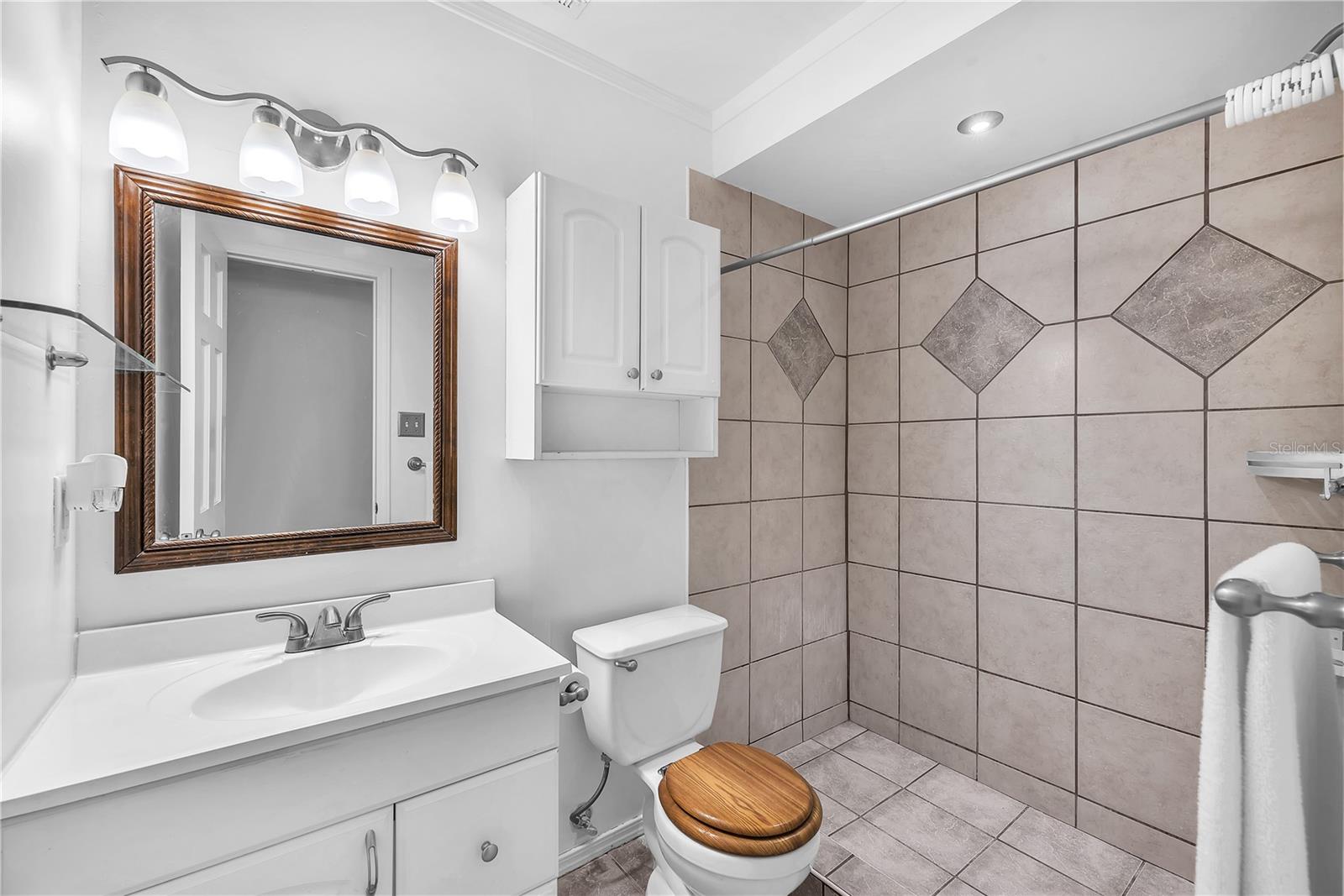 Shared full bathroom with large step-in shower.