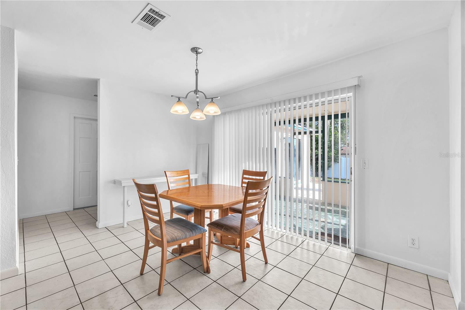 Sliding glass doors lead to a private patio and a spacious, shaded backyard—an inviting setting for relaxing evenings, weekend gatherings, or future outdoor projects.