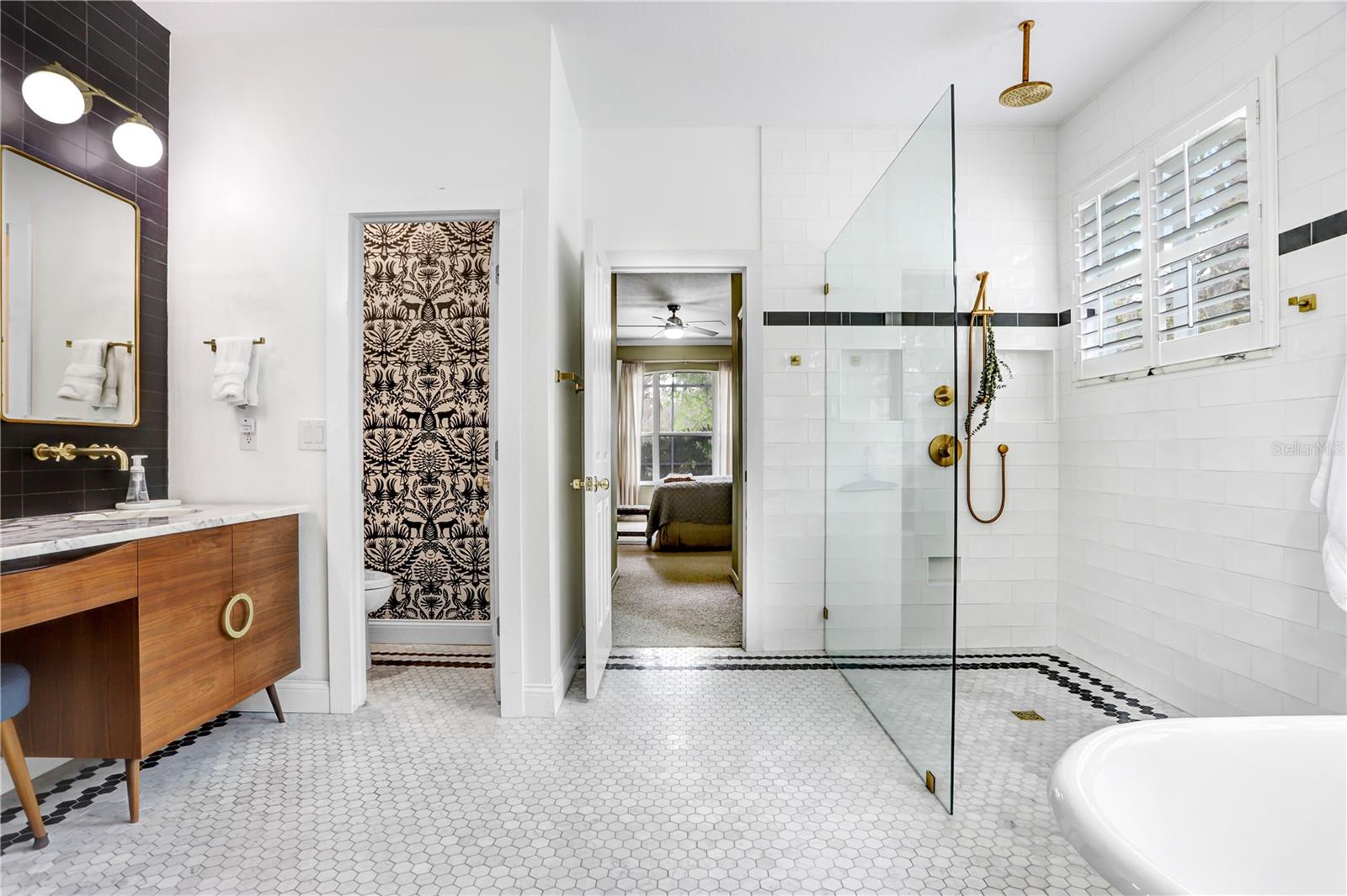 Zero entry shower with seamless glass and marble flooring
