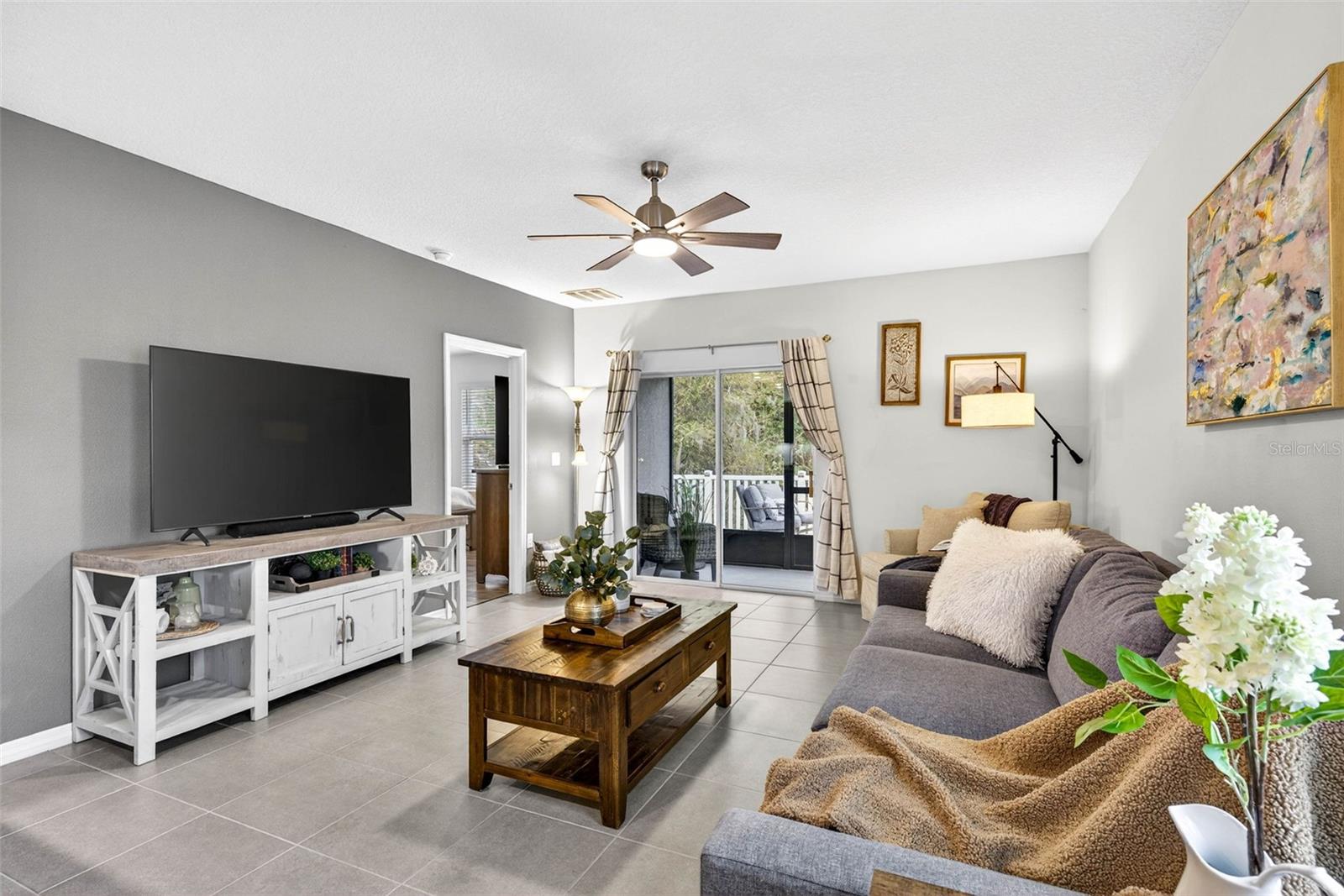 Living room area with overhead lighting/fan.