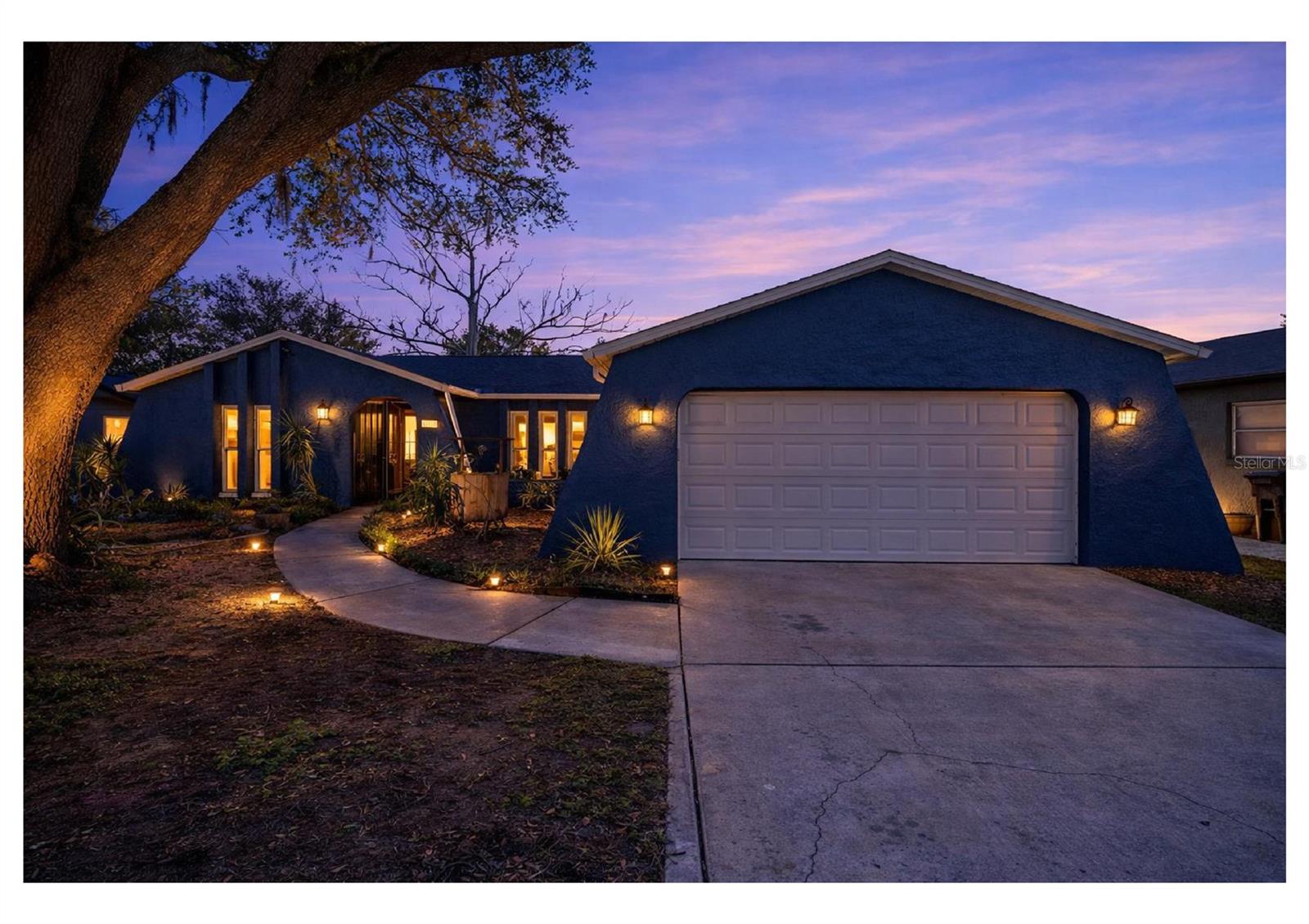 virtually enhanced twilight exterior view highlighting the welcoming entry and mature oak tree.