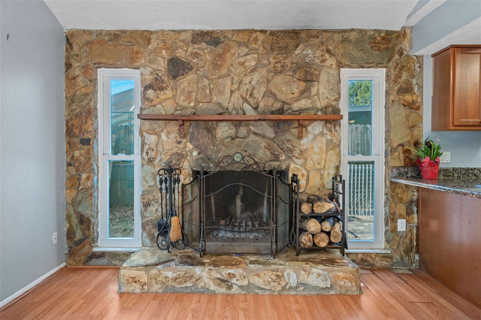 stone wood burning fireplace with vaulted ceiling family room
