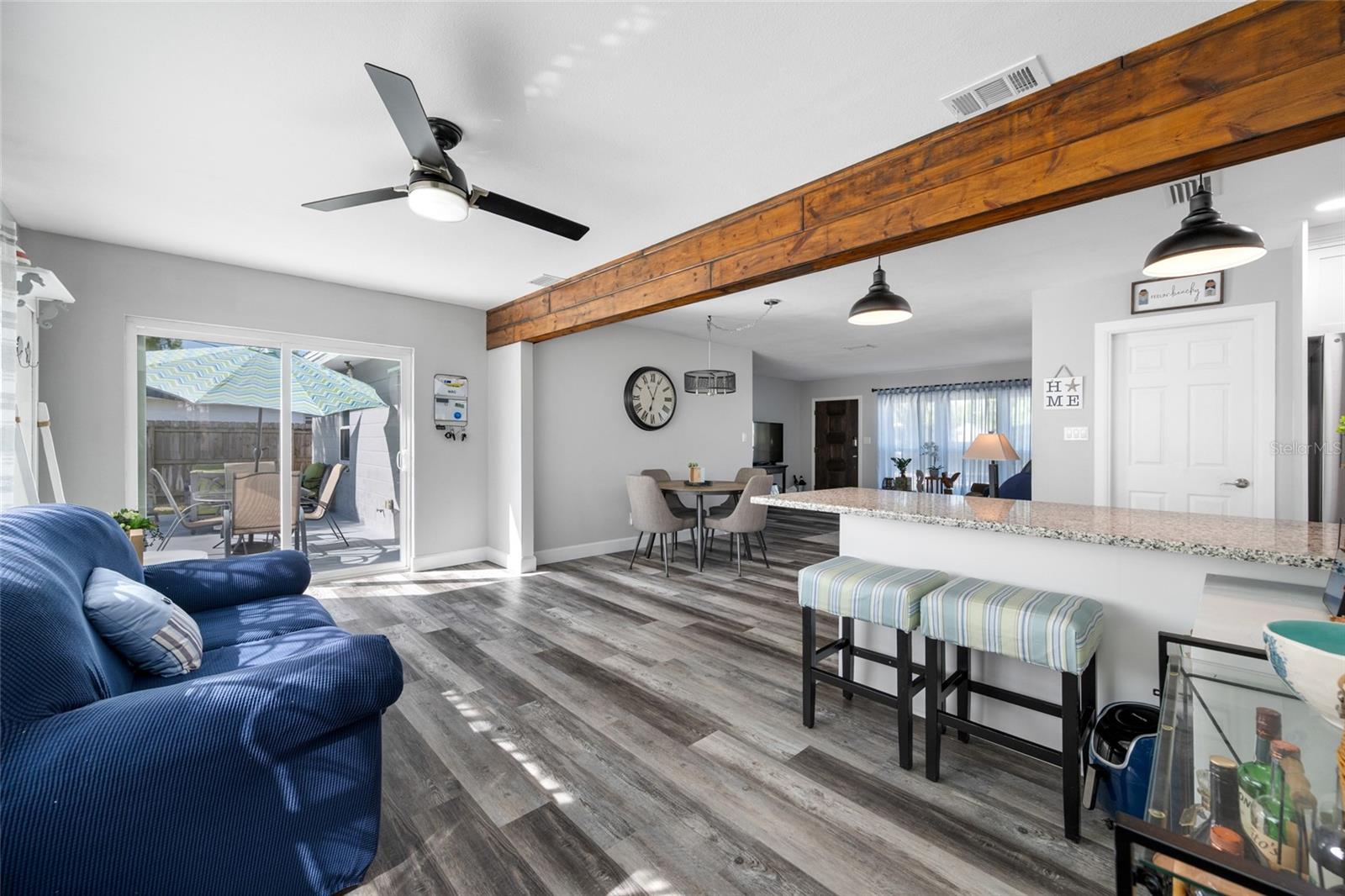 Family Room area with triple windows and slider opening our to the pool deck