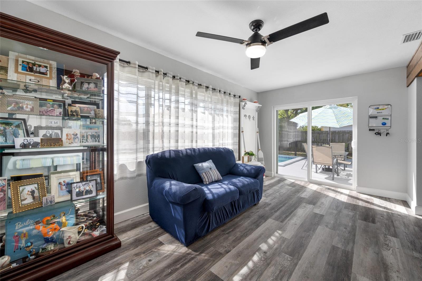 Family Room area with triple windows and slider opening our to the pool deck