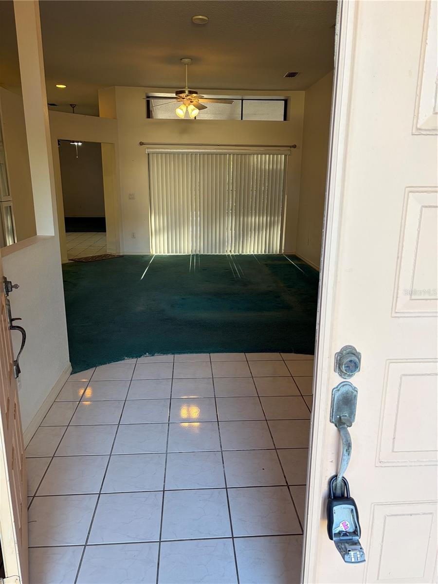 front entrance into living room and sliding glass doors to pool