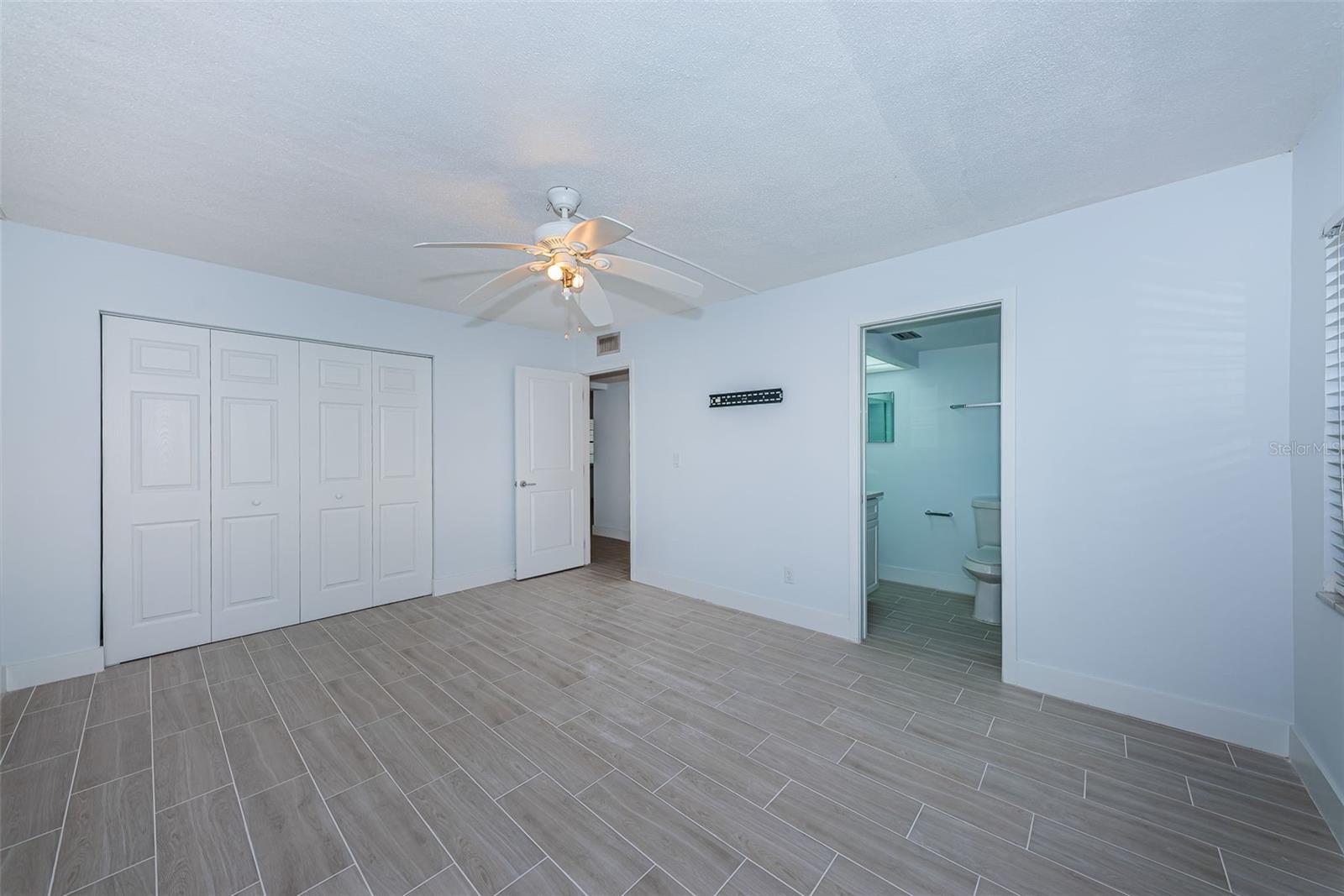 Primary bedroom showing closet and bathroom