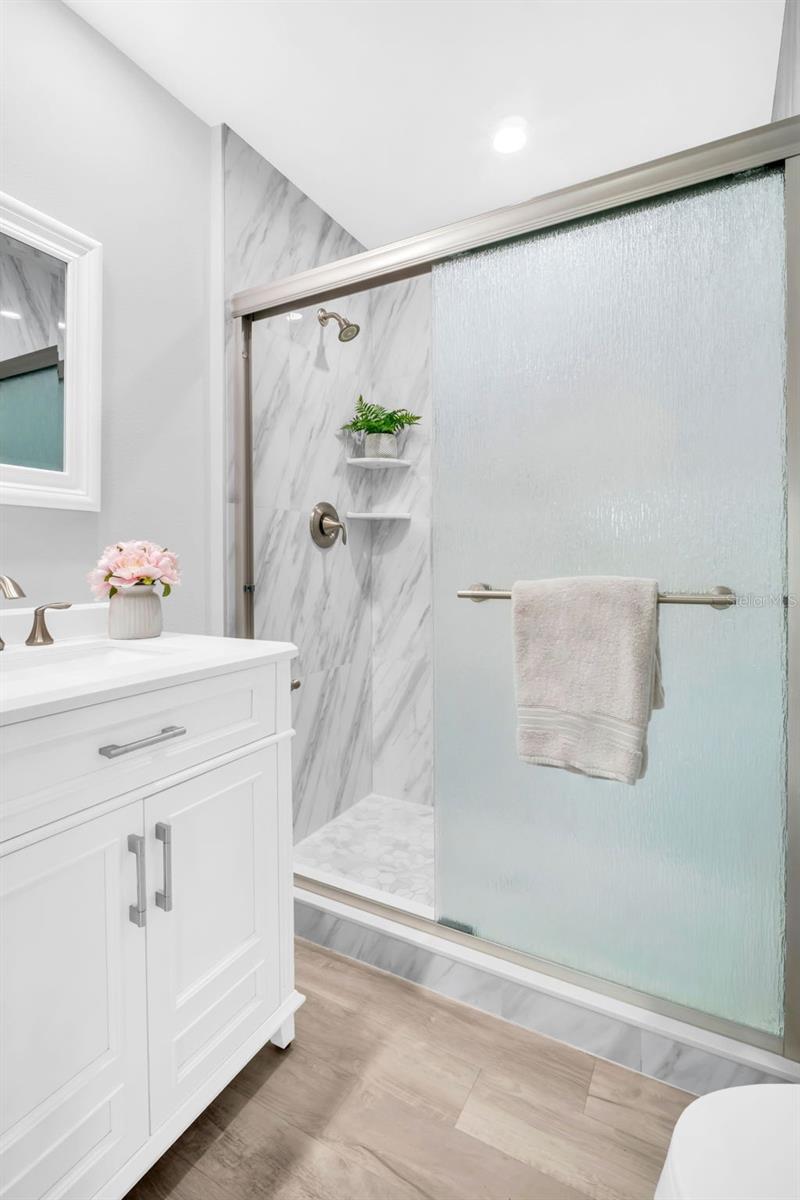 Luxurious new tile step in shower, wood vanity with stone counter & lighting~