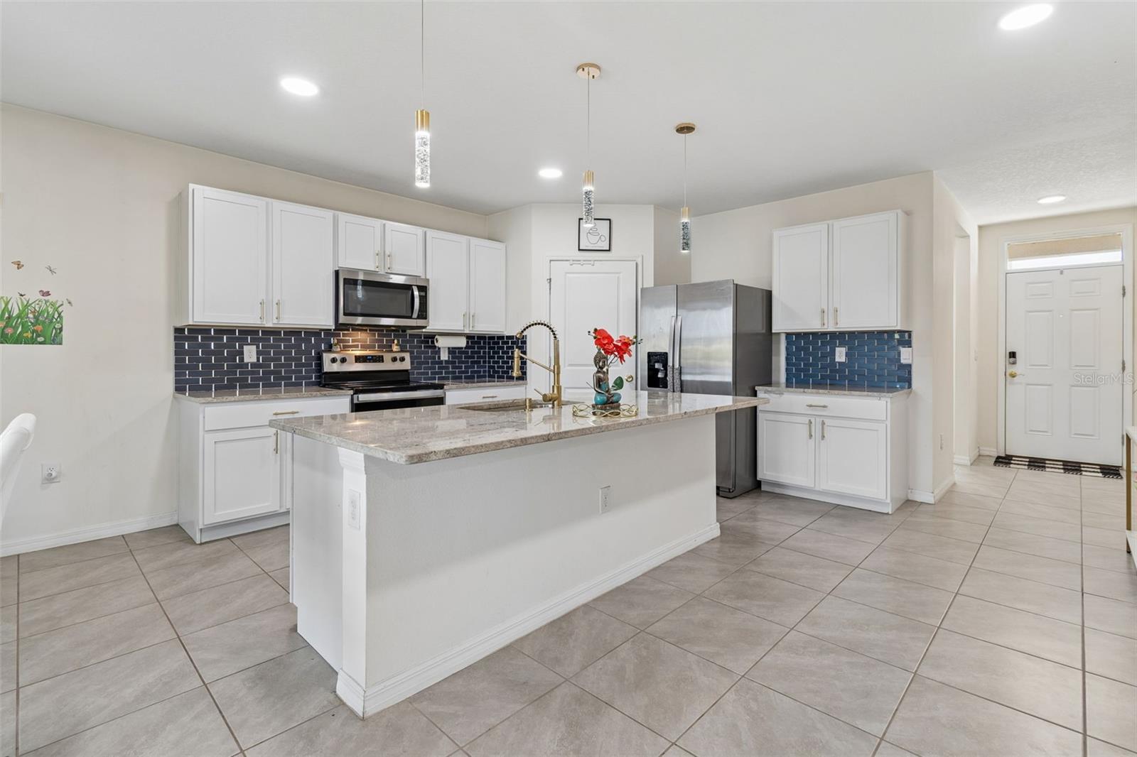 Upgraded tile backsplash, island lighting, and stone countertops