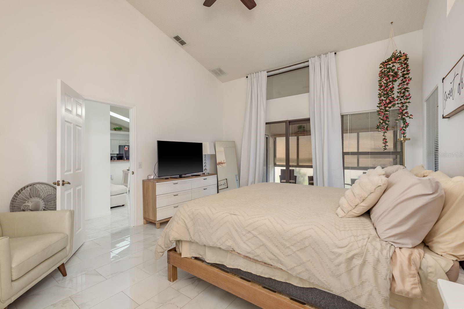 Sliding glass door access to Florida room and patio from primary bedroom