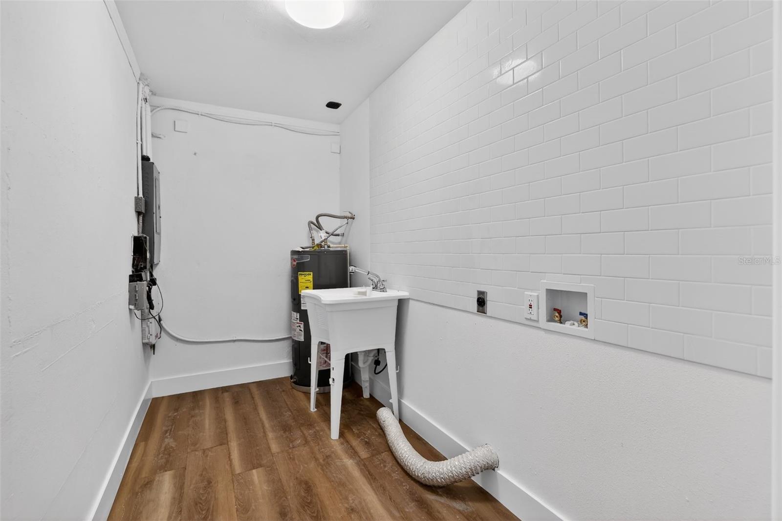 Finished laundry room with tile backsplash