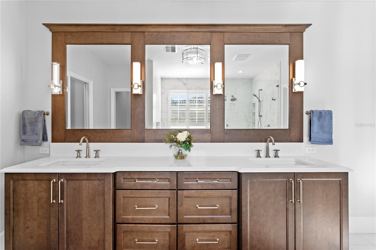 Rich tone cabinetry with split sinks provides loads of storage