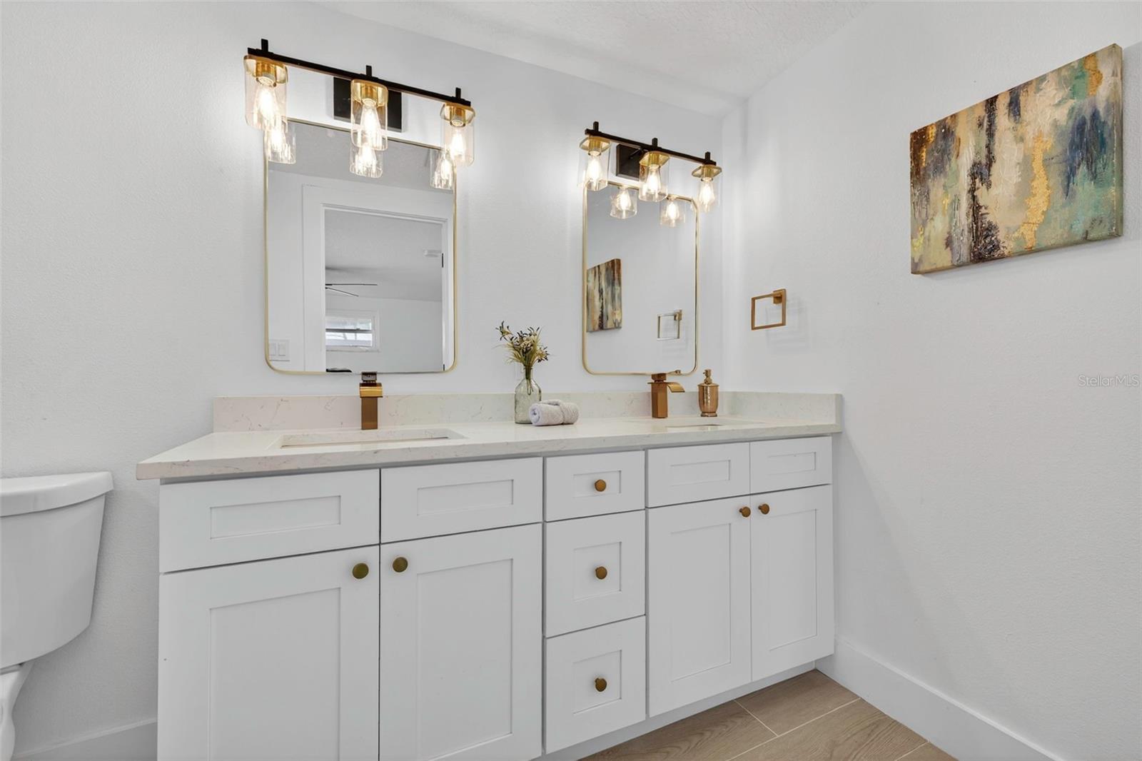 Remodeled primary bathroom with double vanity and modern finishes