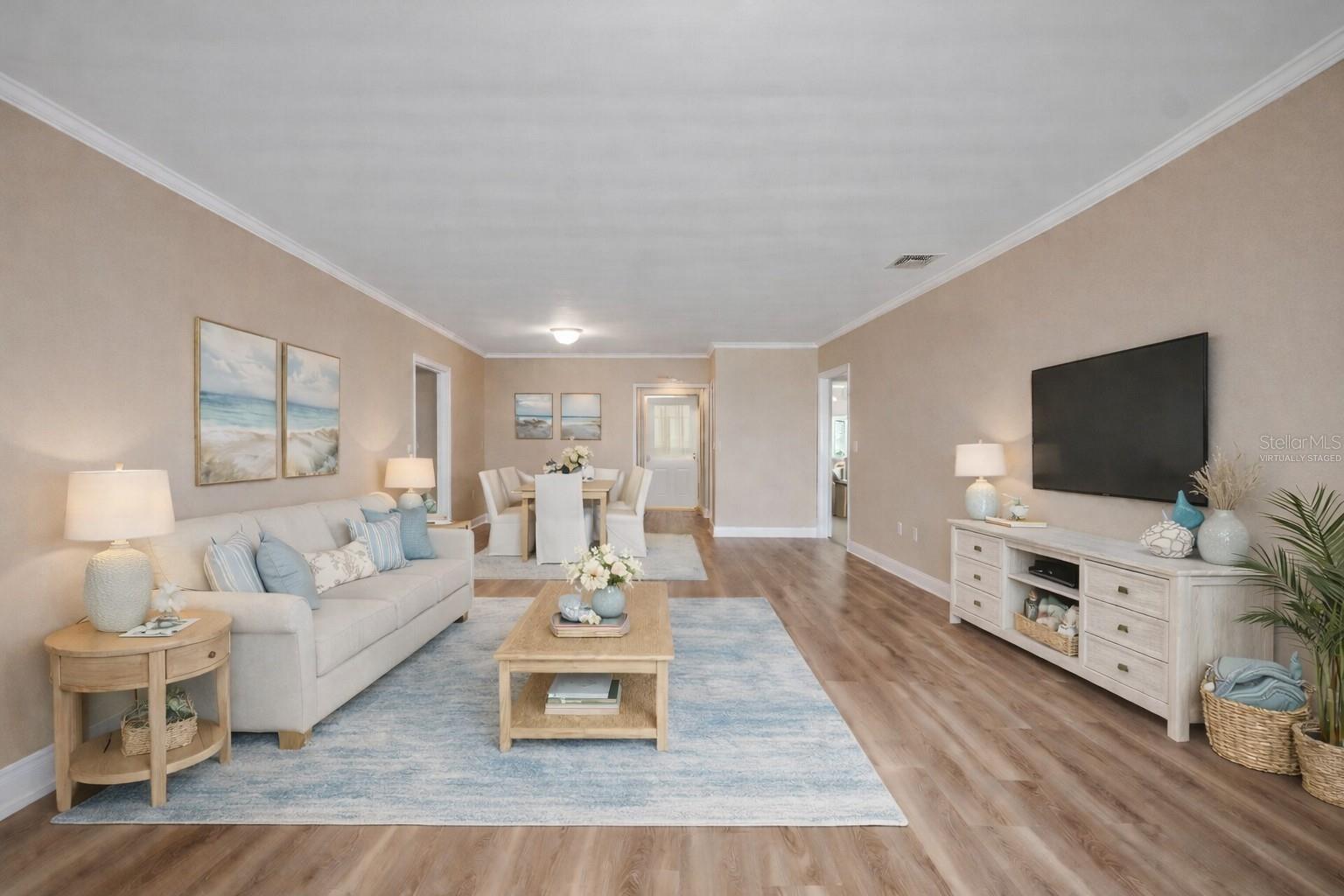 Virtually staged living and dining area. New plank flooring throughout.