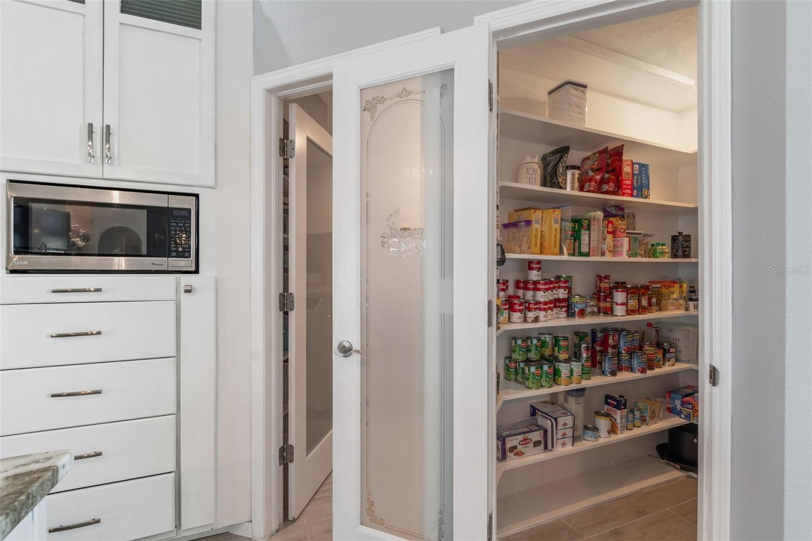 Doors leading into nice-sized walk-in pantry and laundry room that leads to the 2-car garage.
