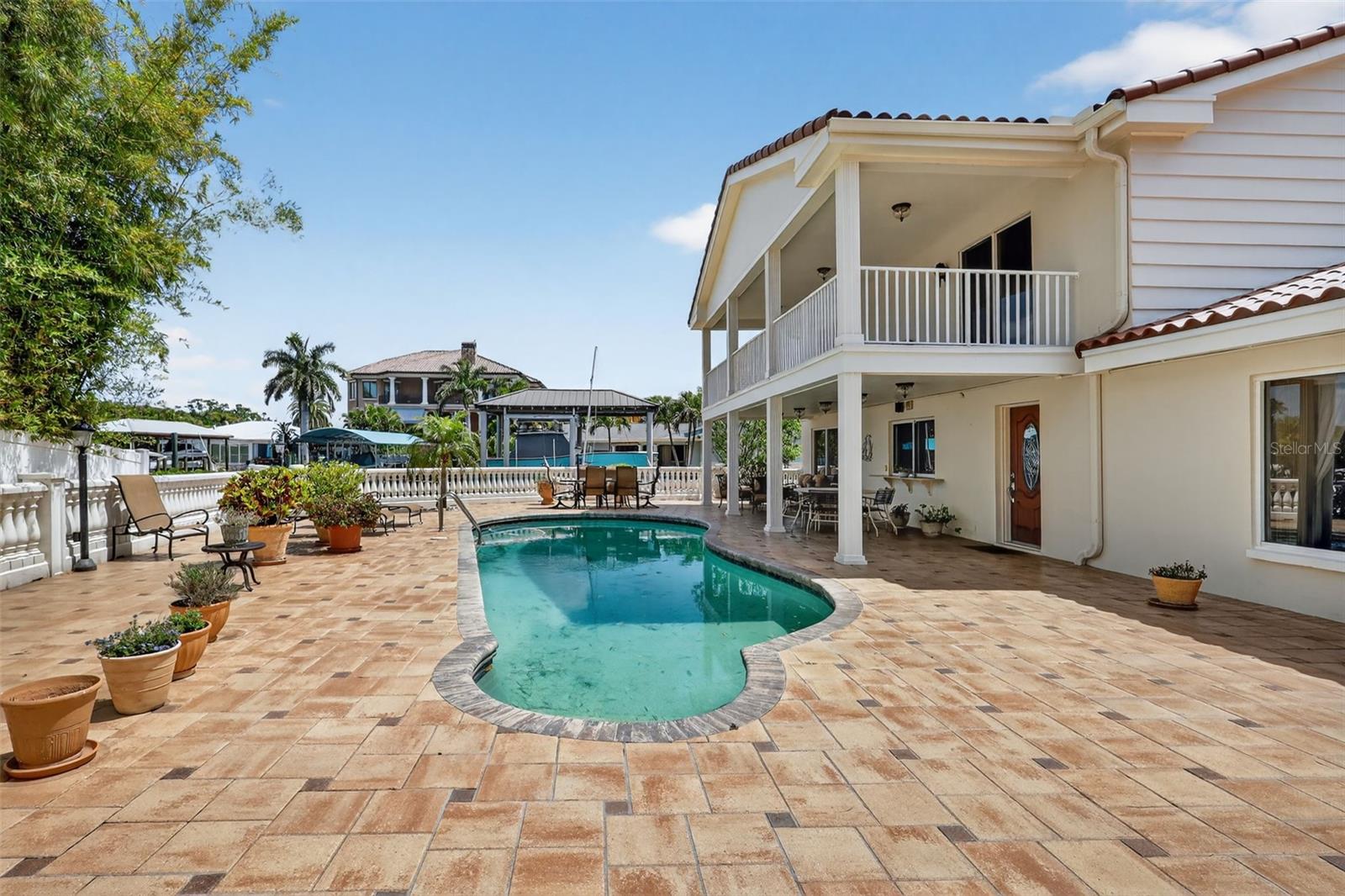 Entering the backyard,you have an extra large pavered patio and pool for daily enjoyment, right on the water!