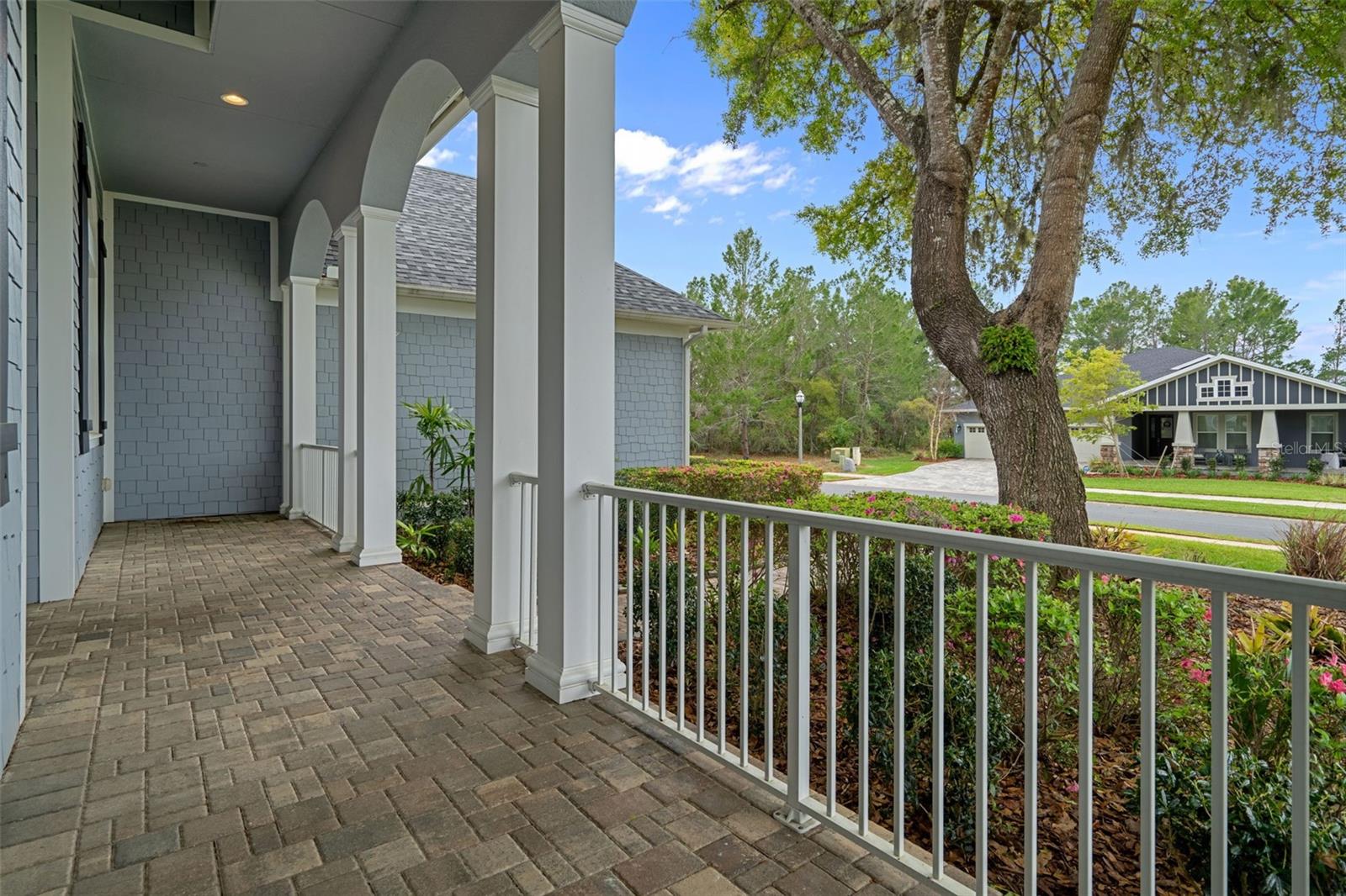 Front Porch with Brick Pavers and Decorative Railings