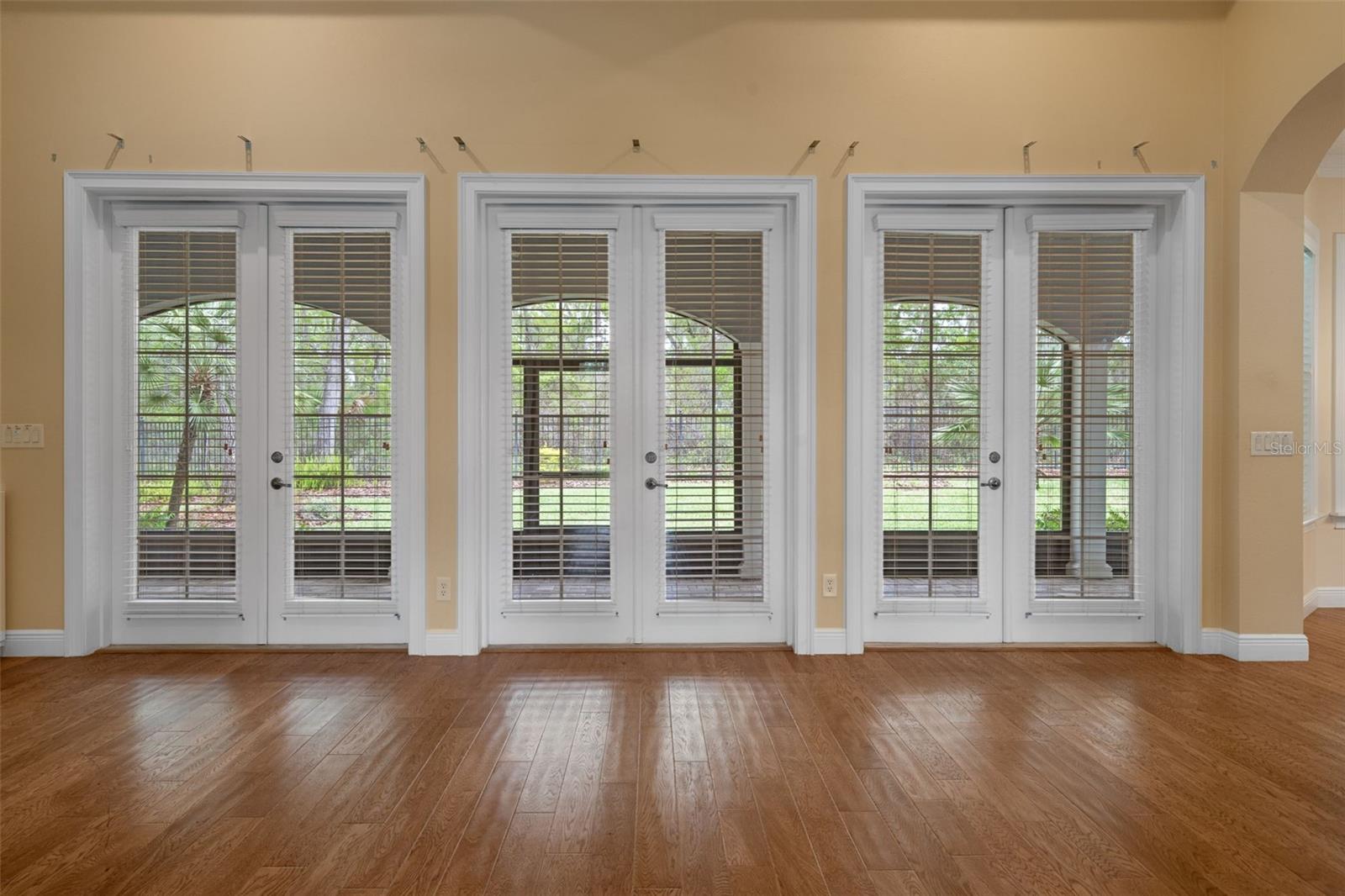 Living Room with Triple French Doors to Covered Lanai