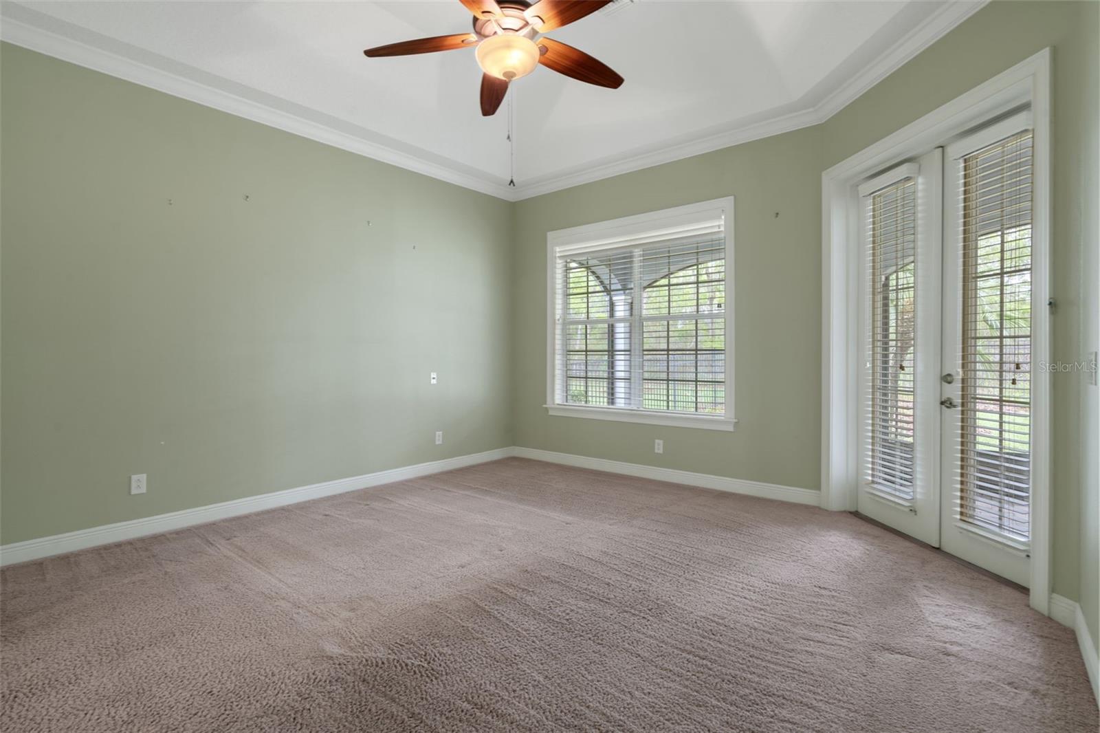 Primary Bedroom with High Ceilings and French Doors to Covered Lanai
