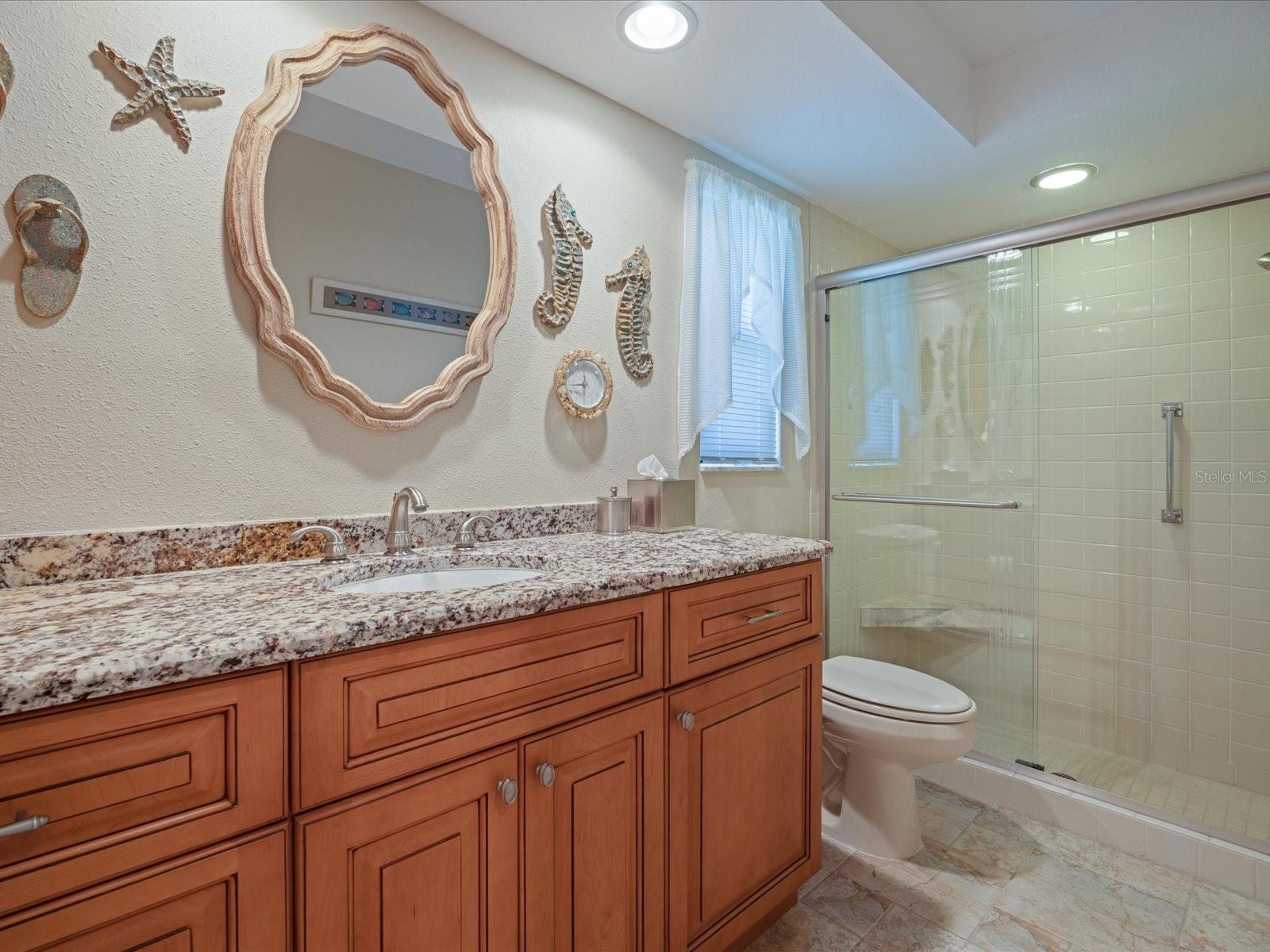 Primary bath with granite top and wood vanity
