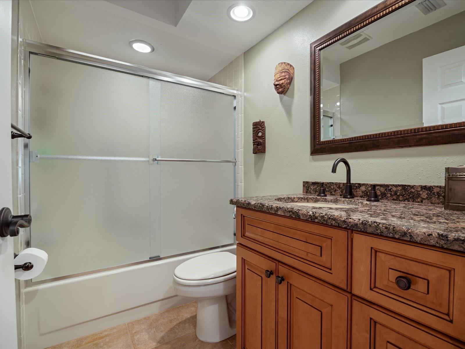 Guest bathroom with granite top and wood vanity