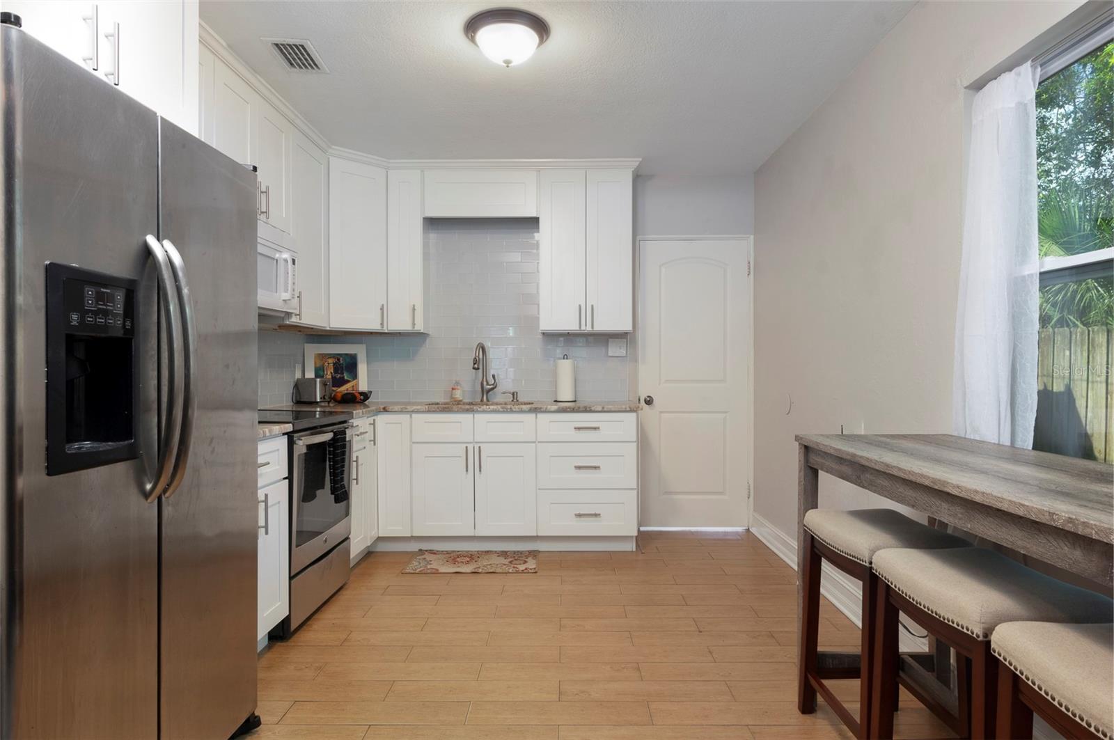 Updated kitchen features stainless steel appliances, granite countertops, and dining nook, ideal for everyday living or morning coffee