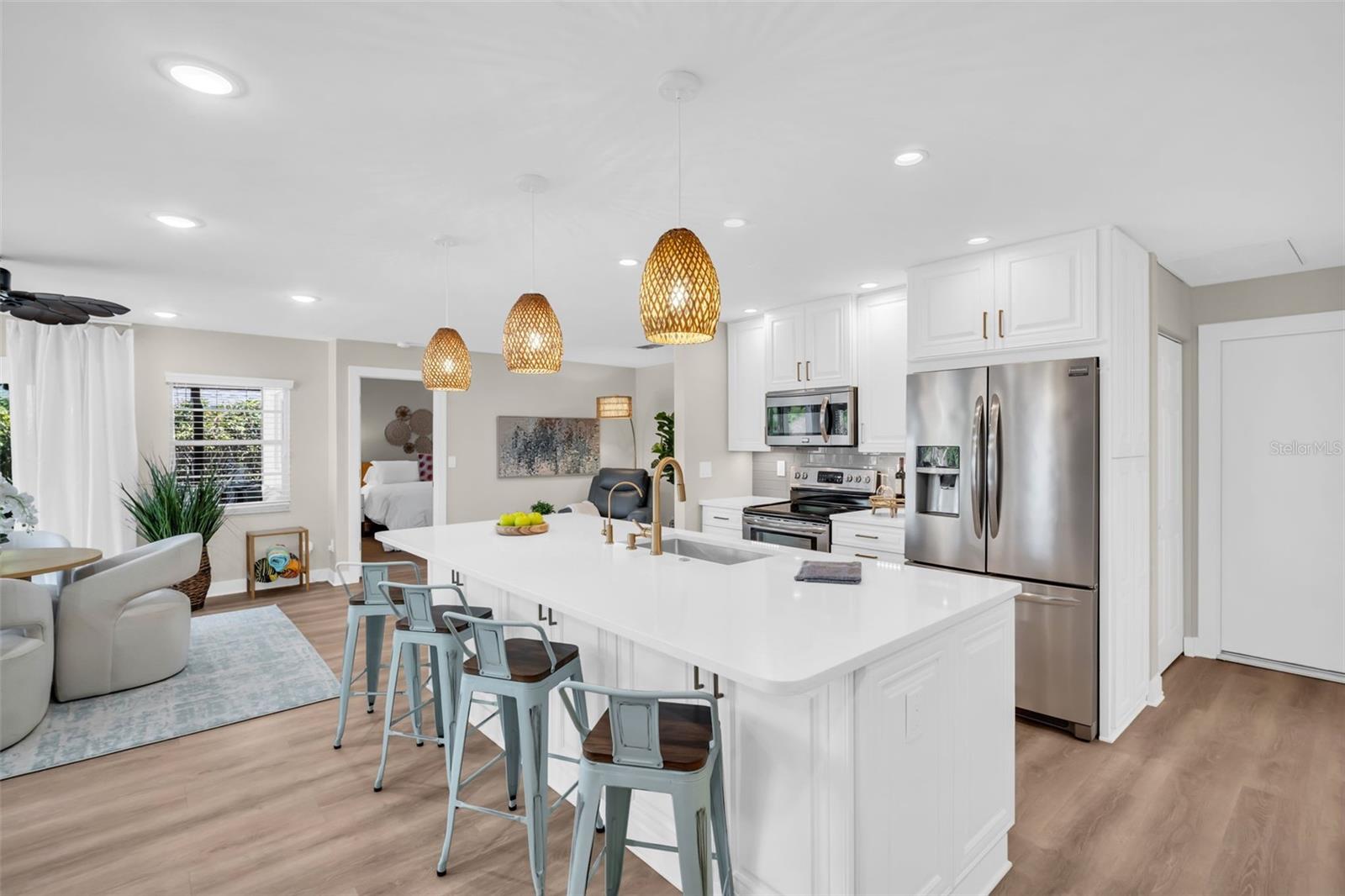 Large island with bar seating, quartz countertops, beautifully updated lighting~