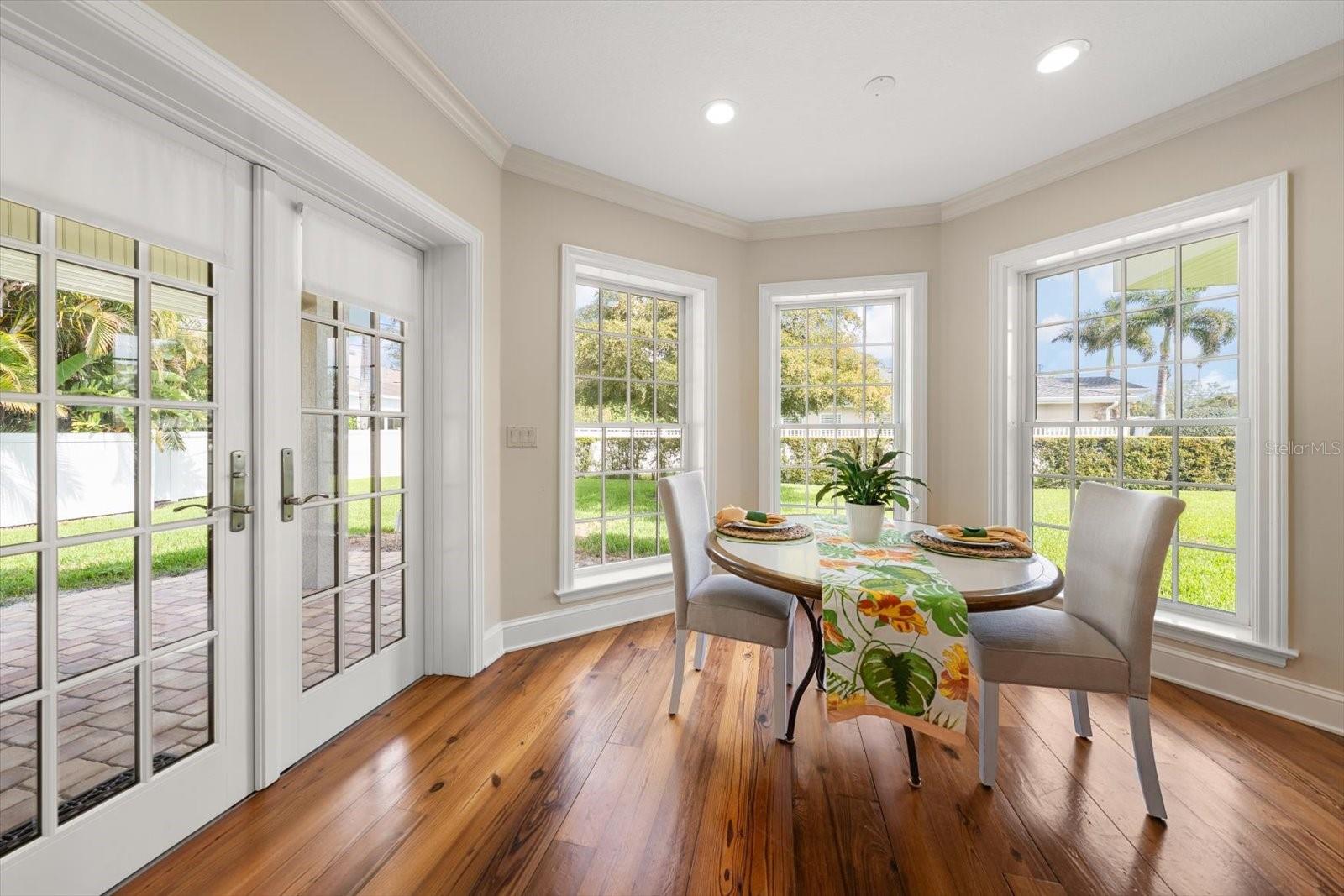 With floor-to-ceiling windows and French doors flanking this sun-drenched dinette, this is a cheerful spot for morning coffee!