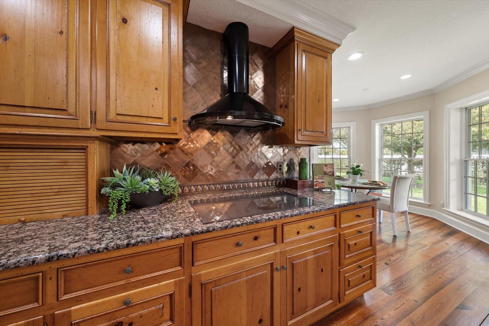 Induction oven with vented hood, appliance garages and dimensional back splashes enhance the kitchne so rich in details.