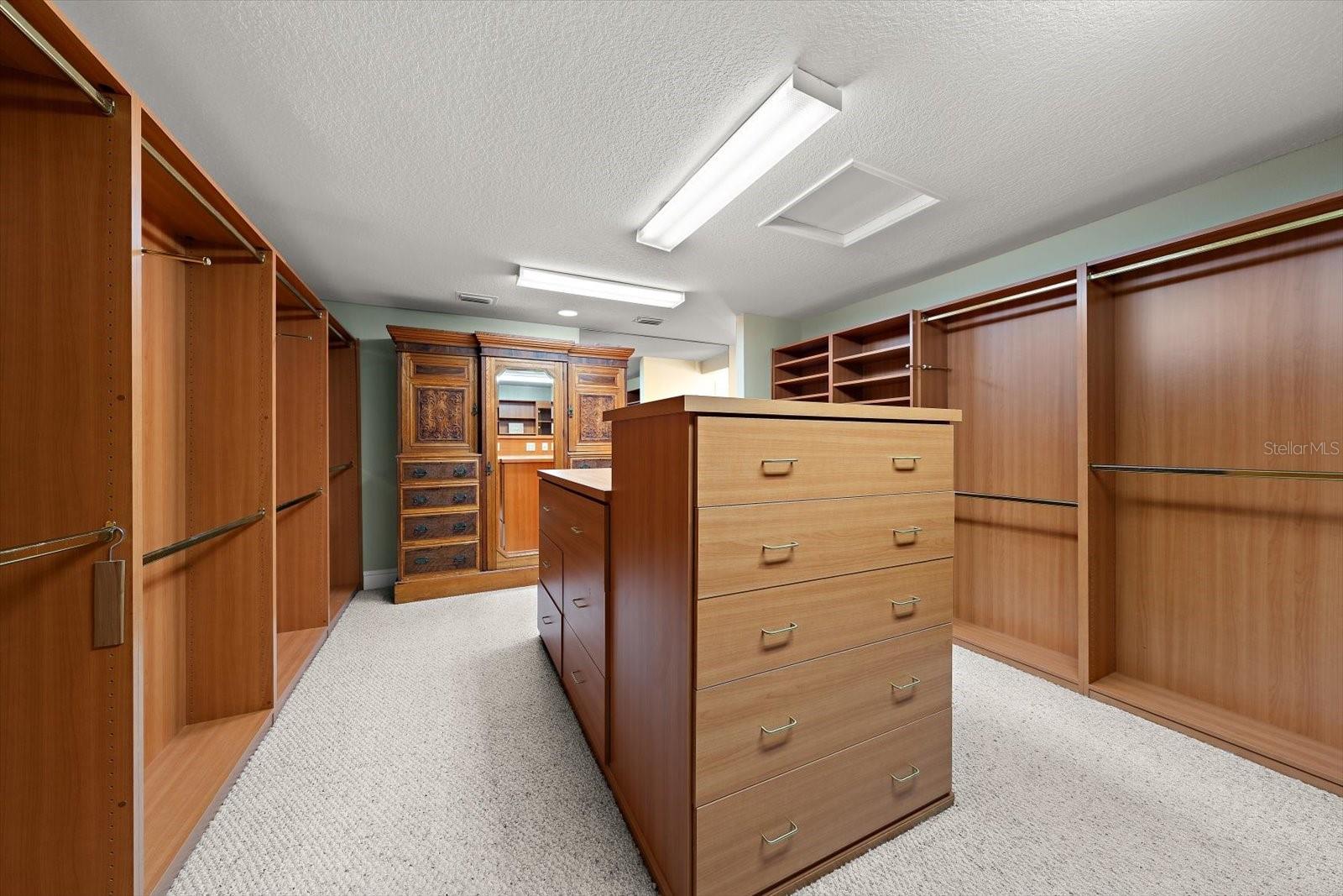 Primary bedroom has boutique style closet- this is a "room sized" built in closet with custom shelving, cabinetry, and thoughtful finishes to accomadate the most extensive wardrobes.