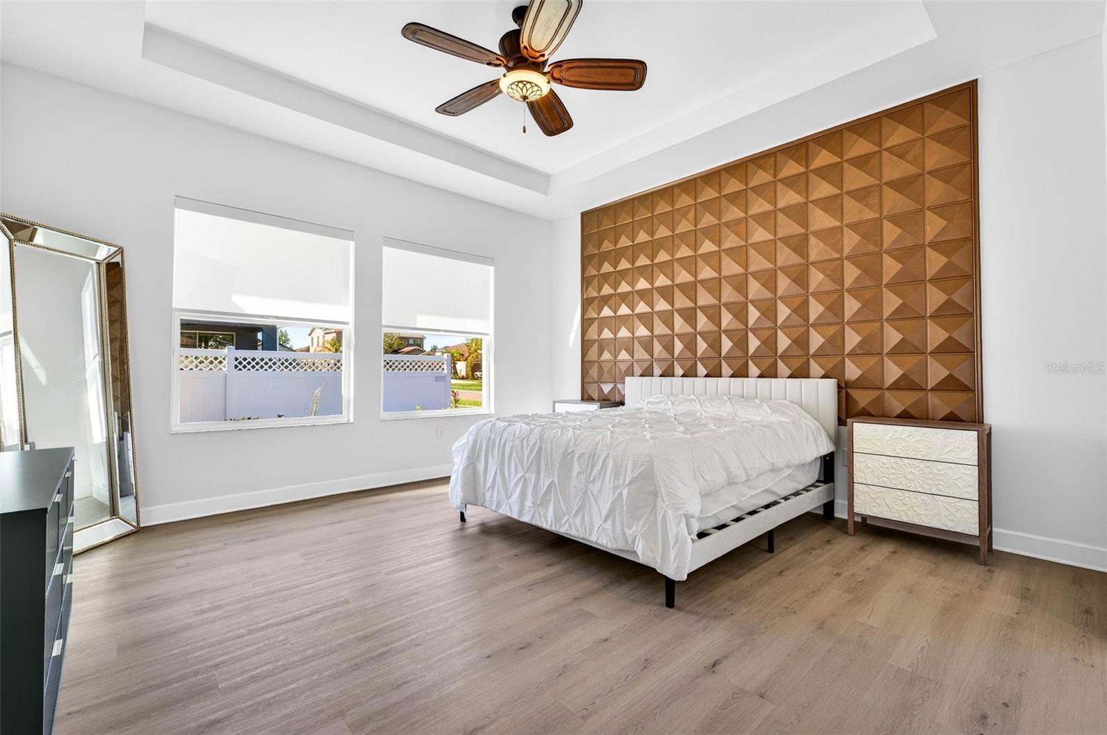 Primary bedroom with feature wall, upgraded flooring NO CARPET! & open views of the backyard.