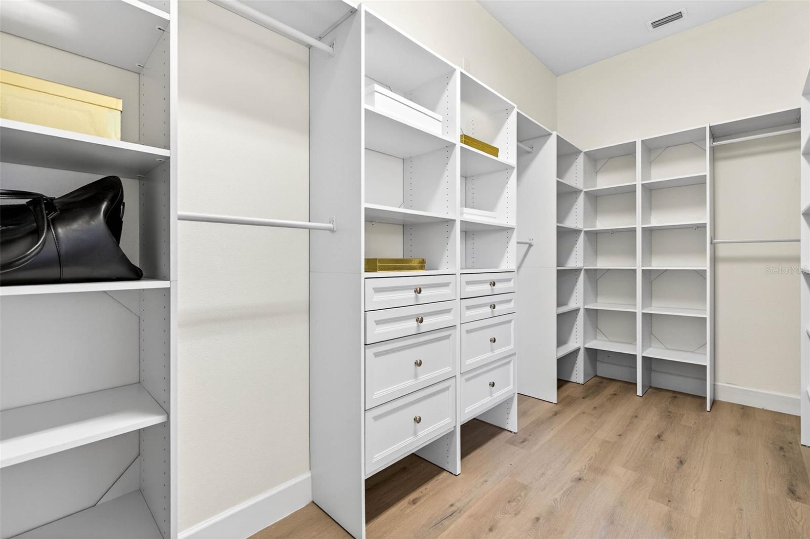 Walk in closet to the primary fully outfitted with built in closet system.