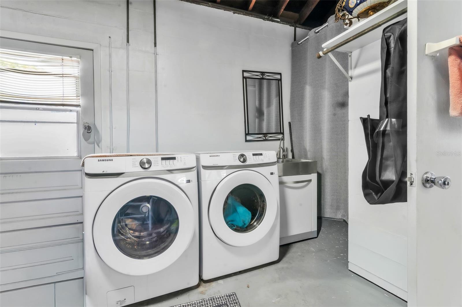 laundry with sink, shower and toilet in garage