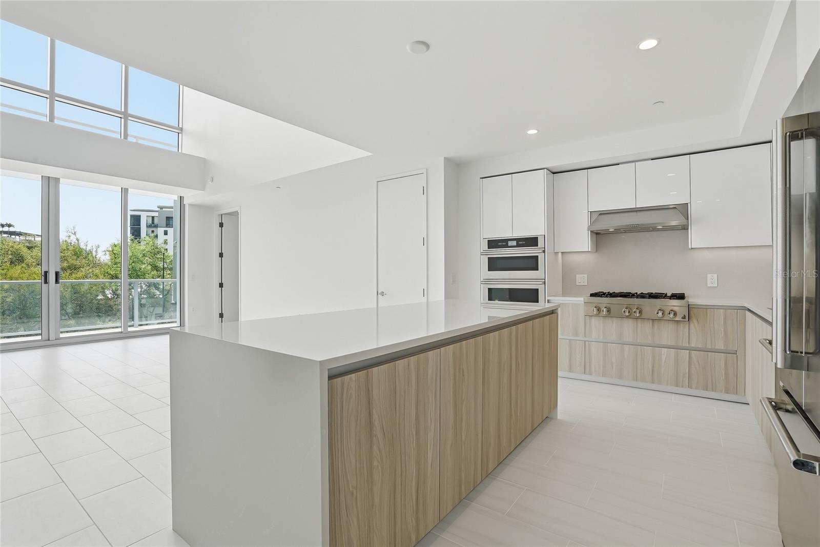 Expansive waterfall edge center island with storage and can fit four barstools so fun to hang out with the chef!