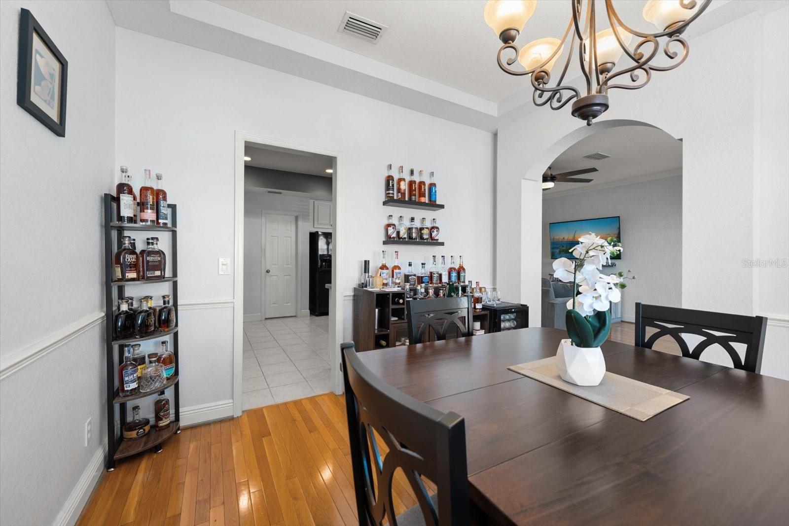 Dining room with hardwood floors and chair rail. Doorways to kitchen and living room