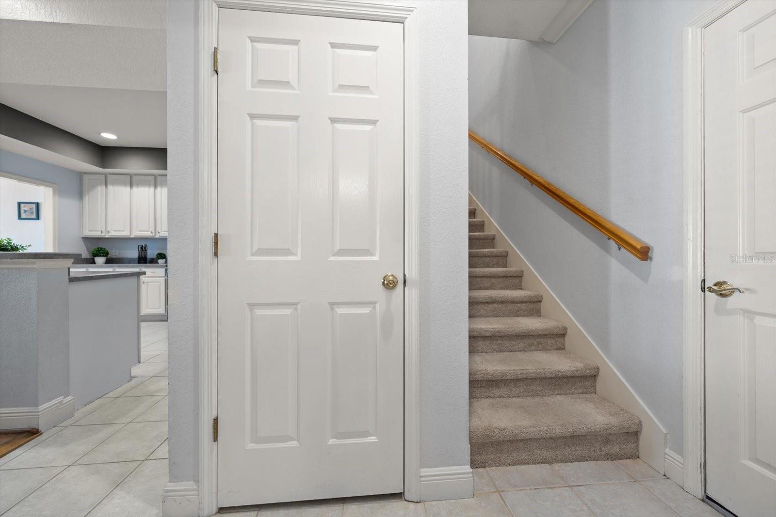 Coat closet, stairs to 2nd floor and door to access garage