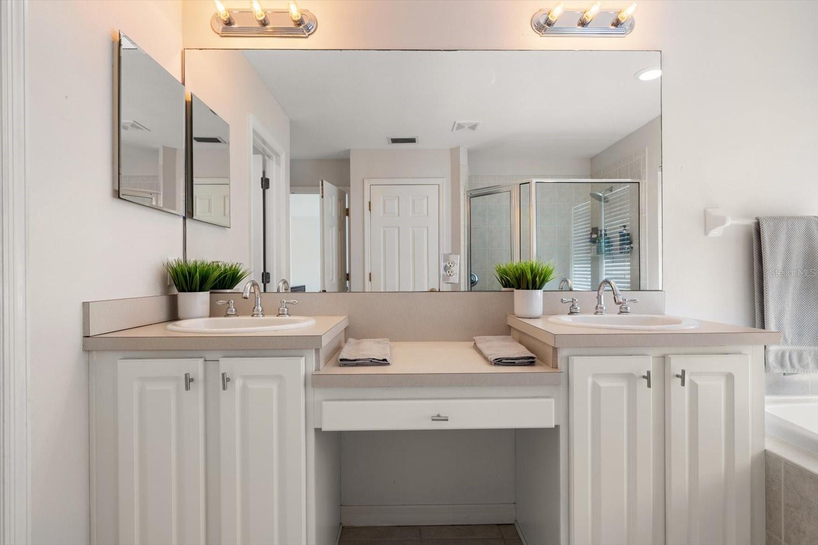 Primary en suite bathroom with dual sinks and vanity