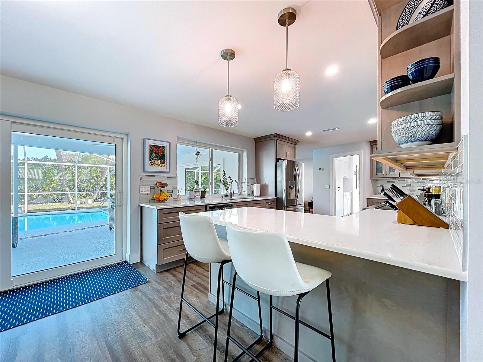 Enjoy guests around the kitchen counter with views of the pool.