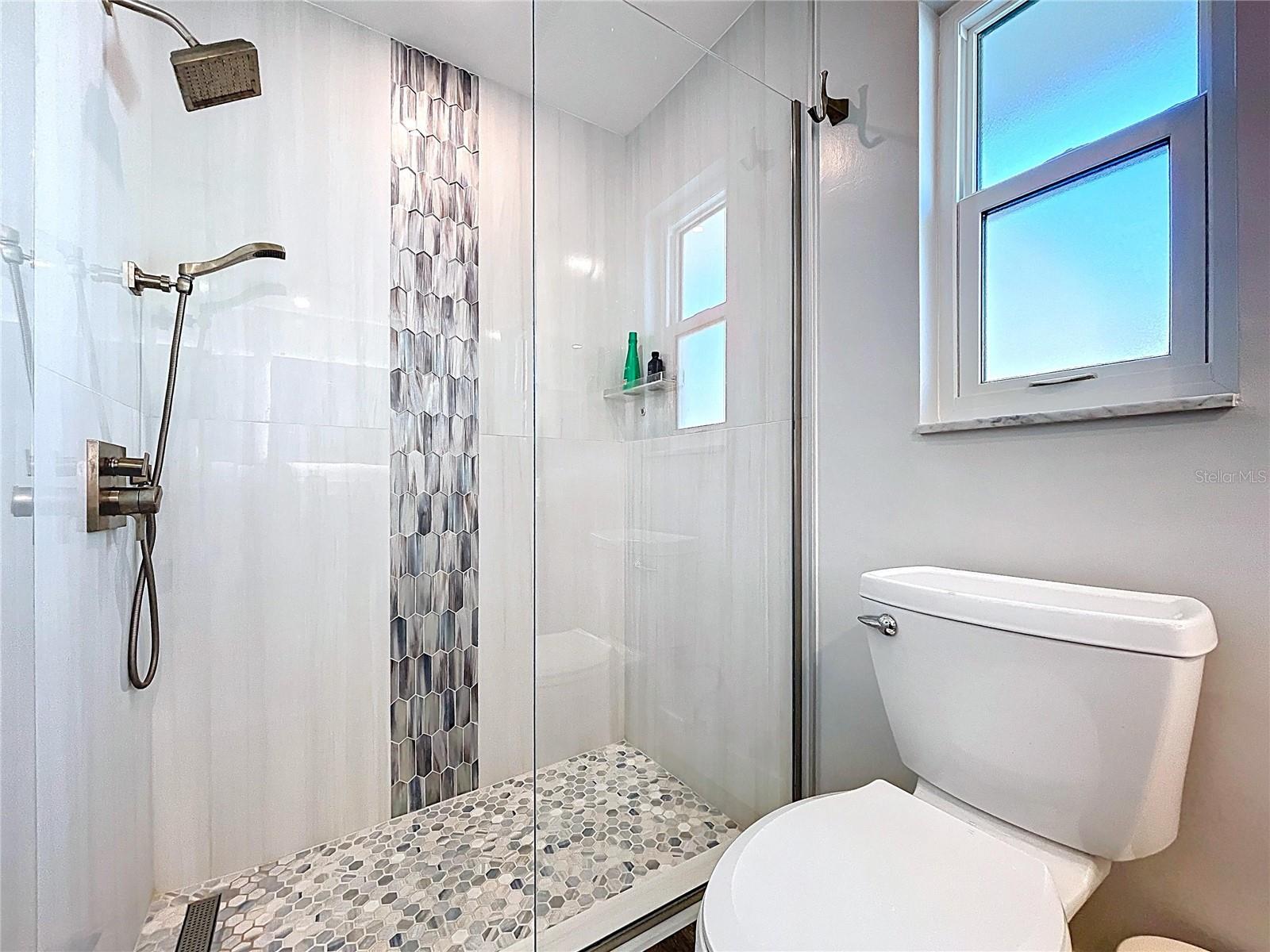 Primary bathroom with walk-in shower and glass door.
