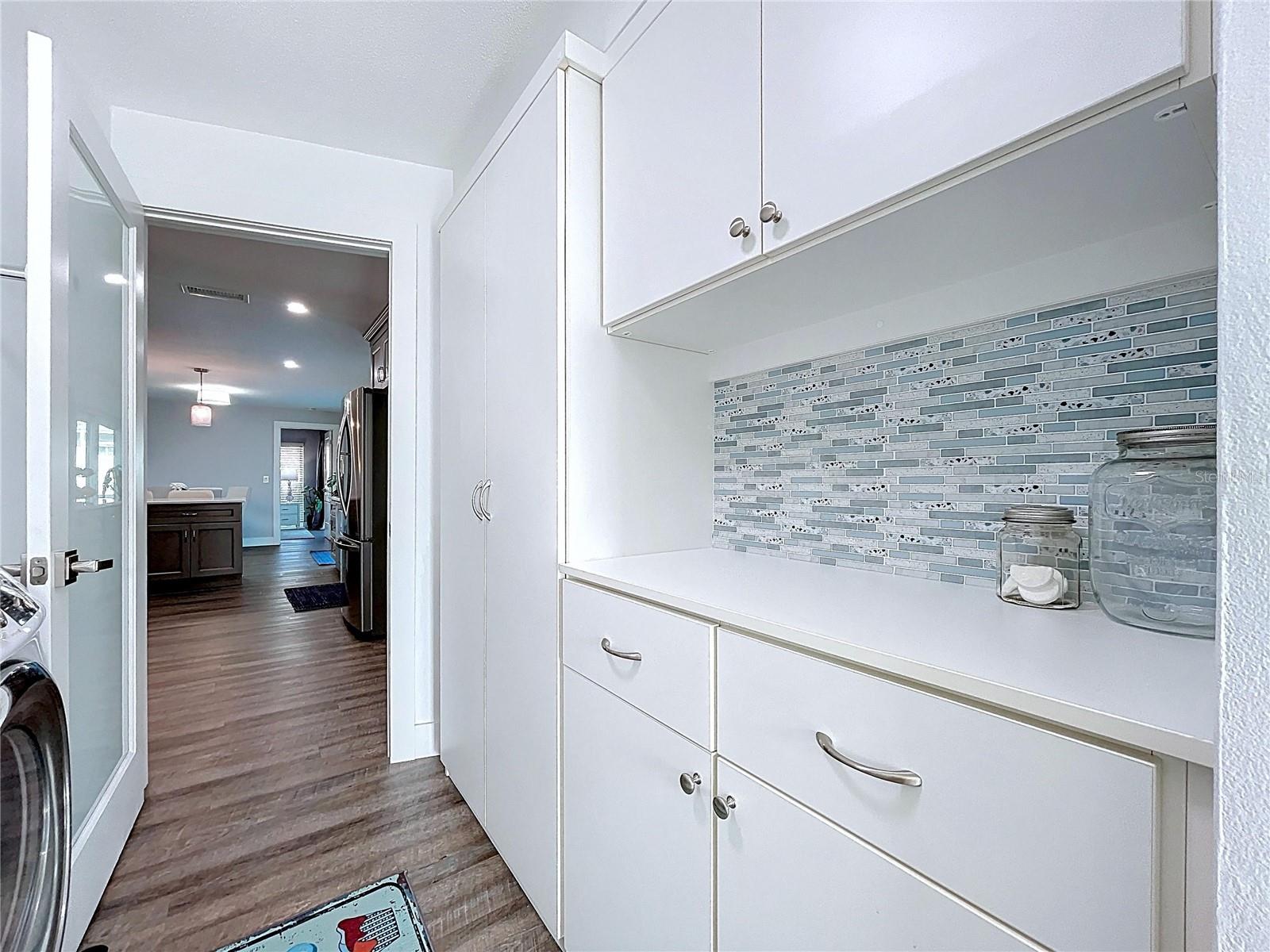 The laundry room offers ample storage and built in cabinets.