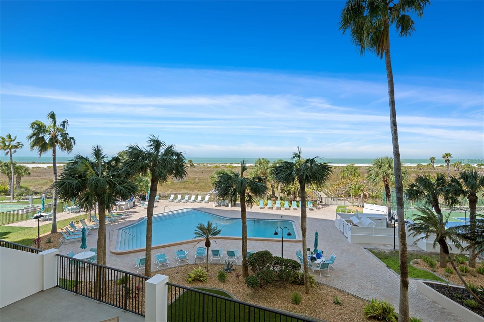 View from patio of 303 of the refreshing pool, spacious deck area & beautiful beach!