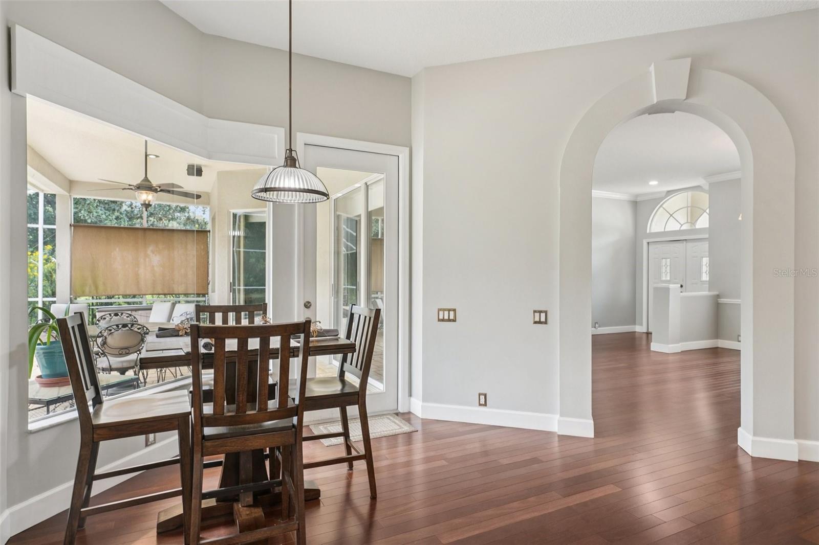 an eat-in breakfast nook with mitered windows providing expansive views of the pool and conservation, recessed lighting, and a seamless flow into the family room.