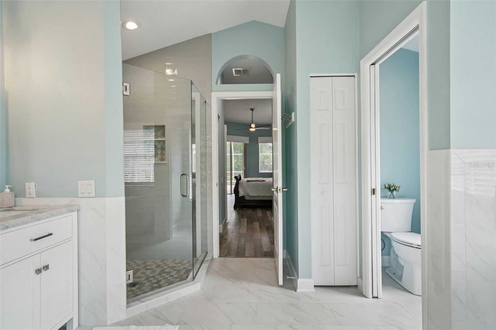 The enviable ensuite bath features marble flooring, dual vanities, a freestanding soaking tub, glass-enclosed shower, private water closet, and linen storage.